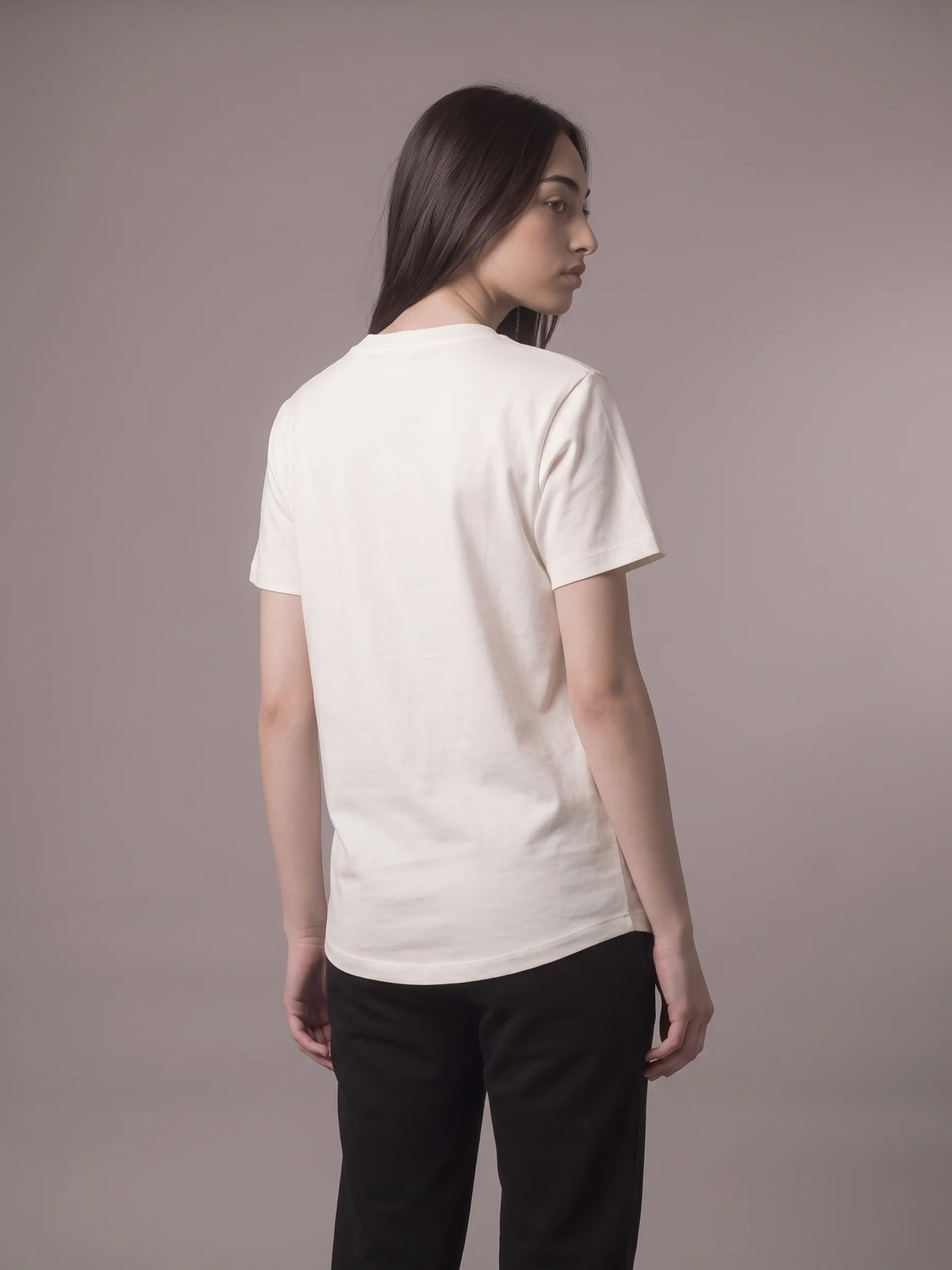 White long fit t-shirt in organic cotton, Unidentity Core Tee, back view worn by woman, styled with black joggers, UAE streetwear #color_white