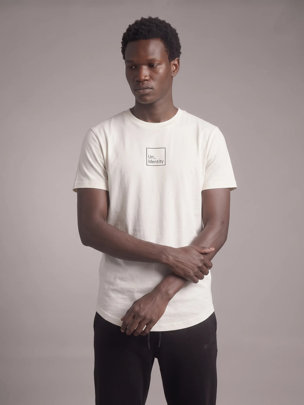 White long fit t-shirt in organic cotton, Unidentity Core Tee, front view on man with minimal boxed chest logo, 210gsm streetwear from Dubai #color_white