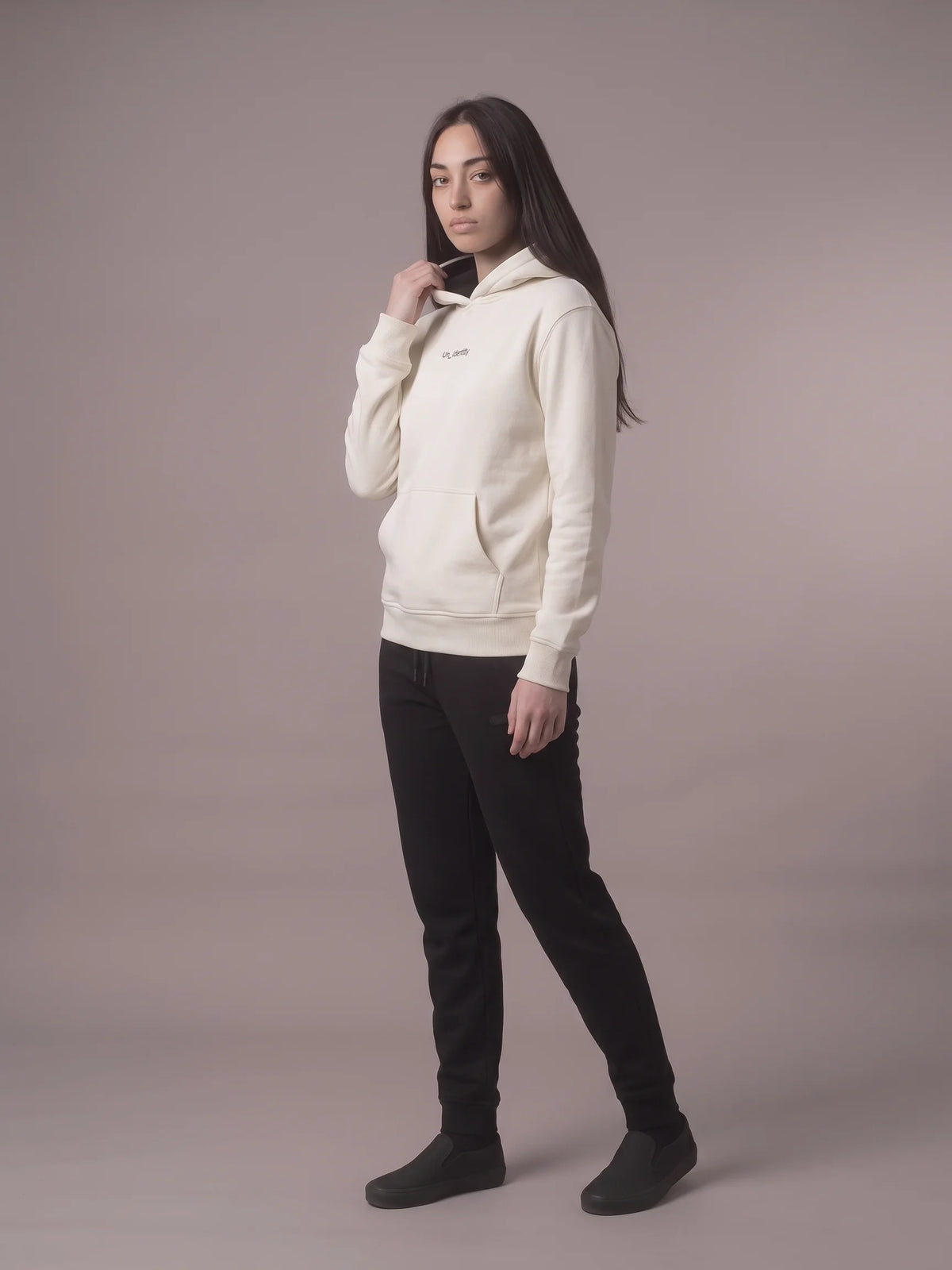 White regular fit hoodie, Unidentity Gem Regular Fit Hoodie, full-length side view worn by woman holding the drawstring, UAE streetwear #color_white