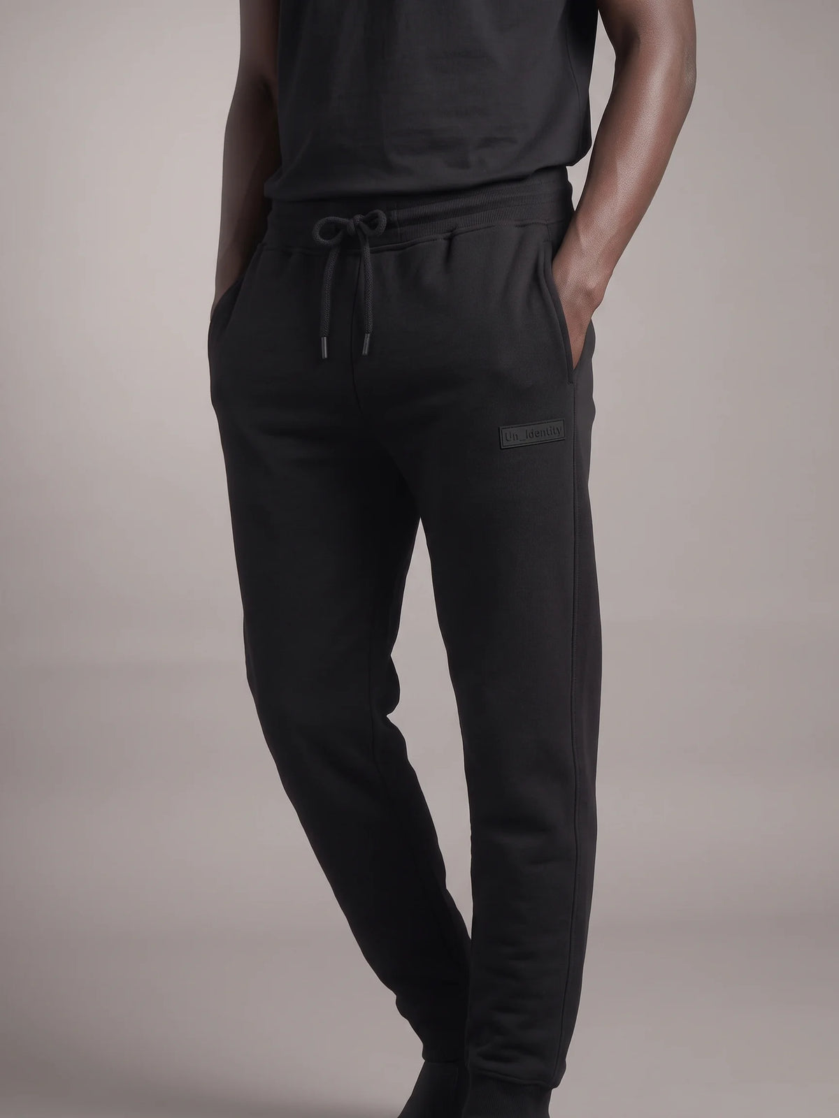 Black sweatpants, Unidentity Core Regular Fit Joggers, front view worn by man showing drawstring waist and side pockets, organic cotton #color_black