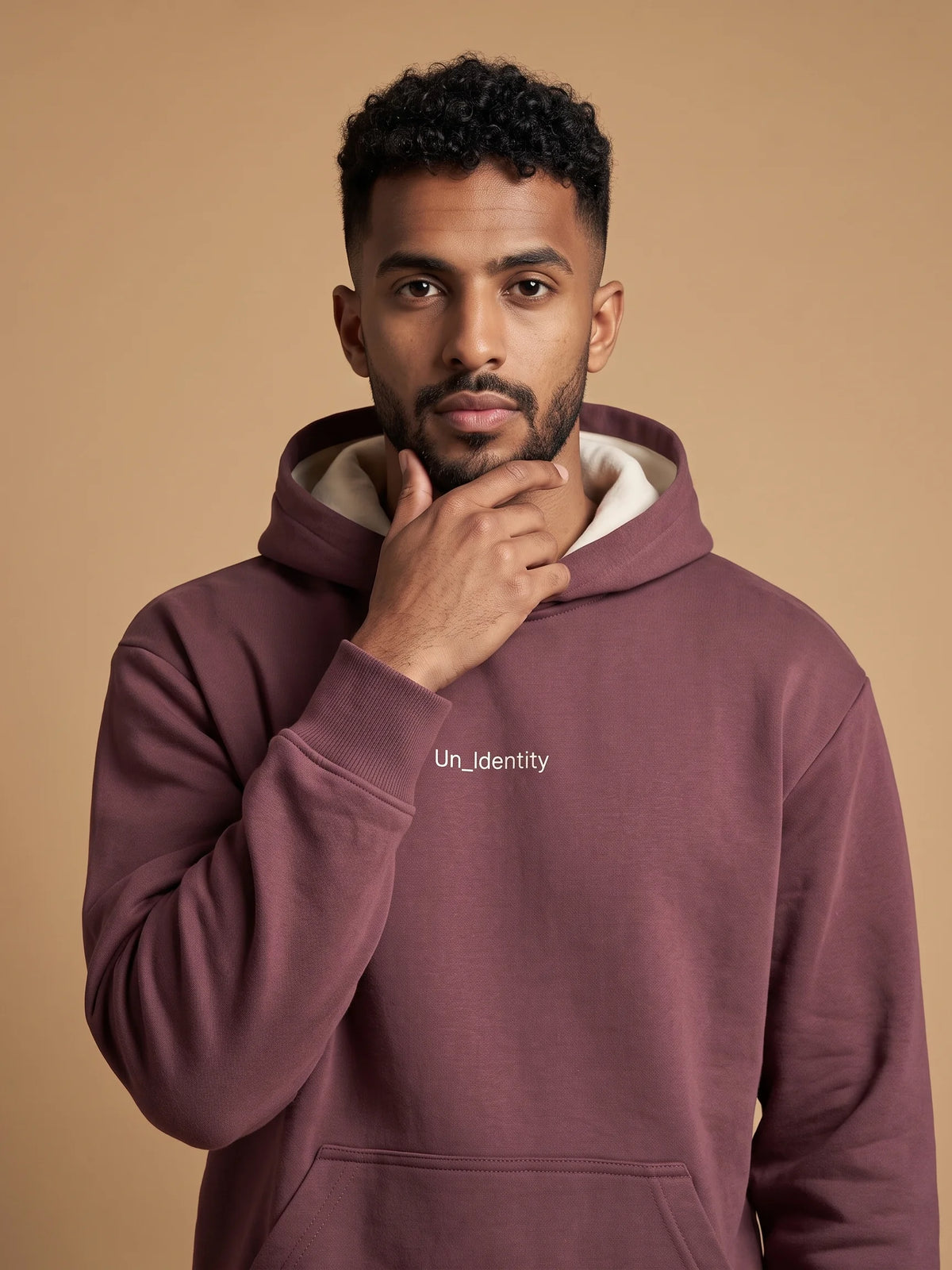 Plum organic cotton hoodie, Unidentity Soul Regular Fit Hoodie, front close-up of the chest logo and kangaroo pocket worn by man, sustainable fashion #color_plum