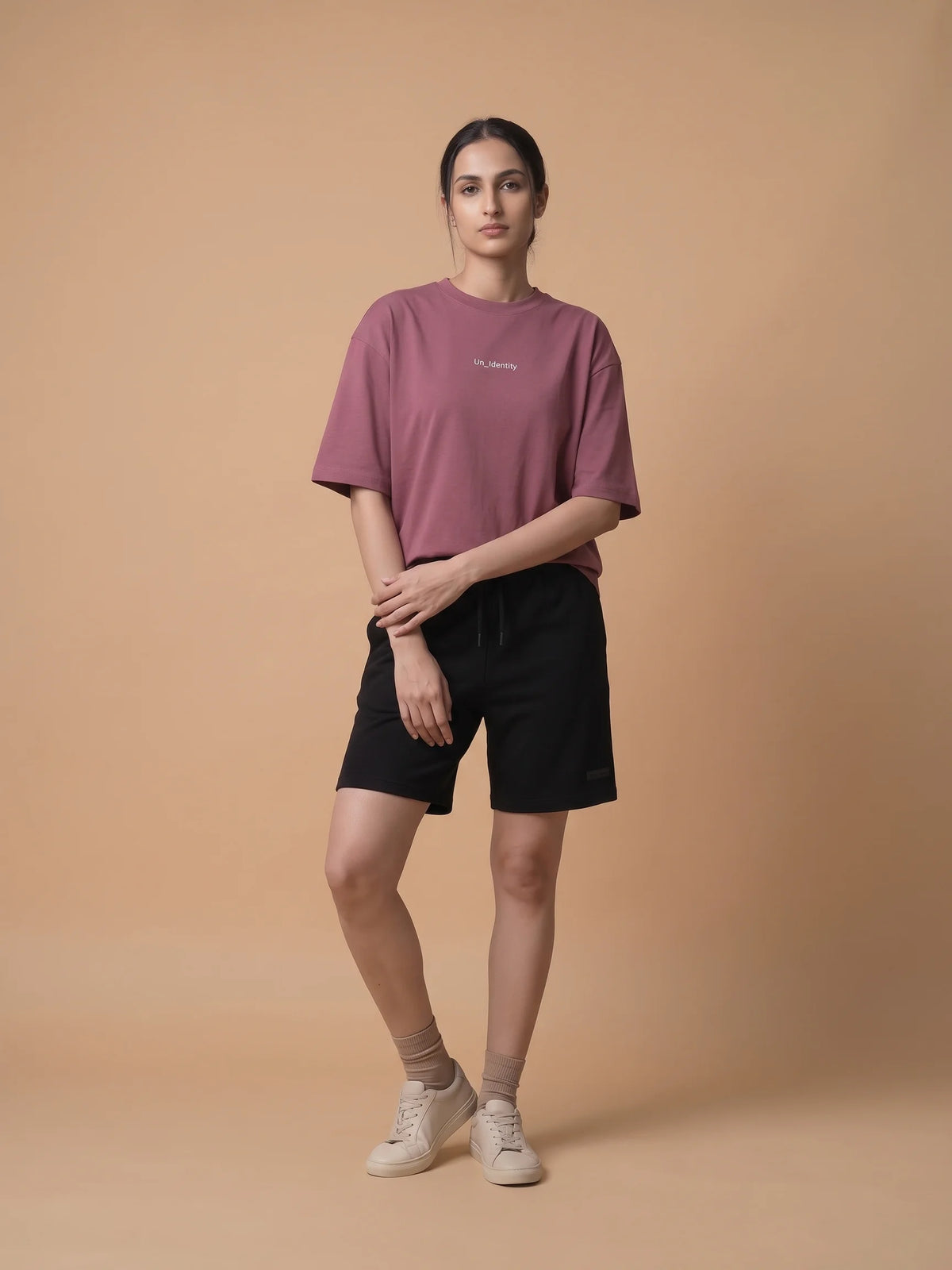 Plum oversized t-shirt, Unidentity Soul Oversized Tee, full-length front view worn by woman styled with black Core shorts, streetwear brand in Dubai #color_plum