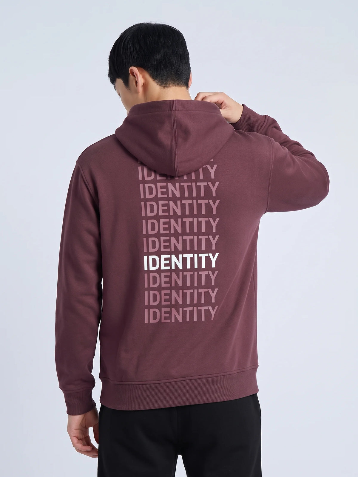 Plum heavyweight hoodie in organic cotton, Unidentity Identity Hoodie, back close-up of the IDENTITY print, hand on his neck, UAE streetwear #color_plum