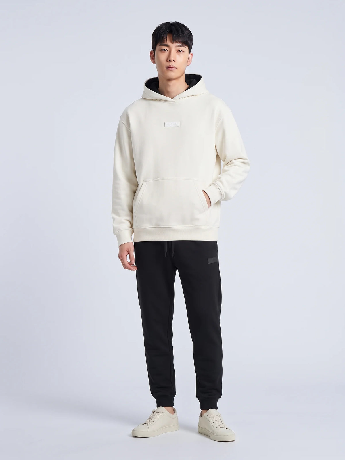 White heavyweight hoodie, Unidentity Identity Regular Fit Hoodie, full-length front view with tonal chest patch and black Core joggers, 390gsm #color_white