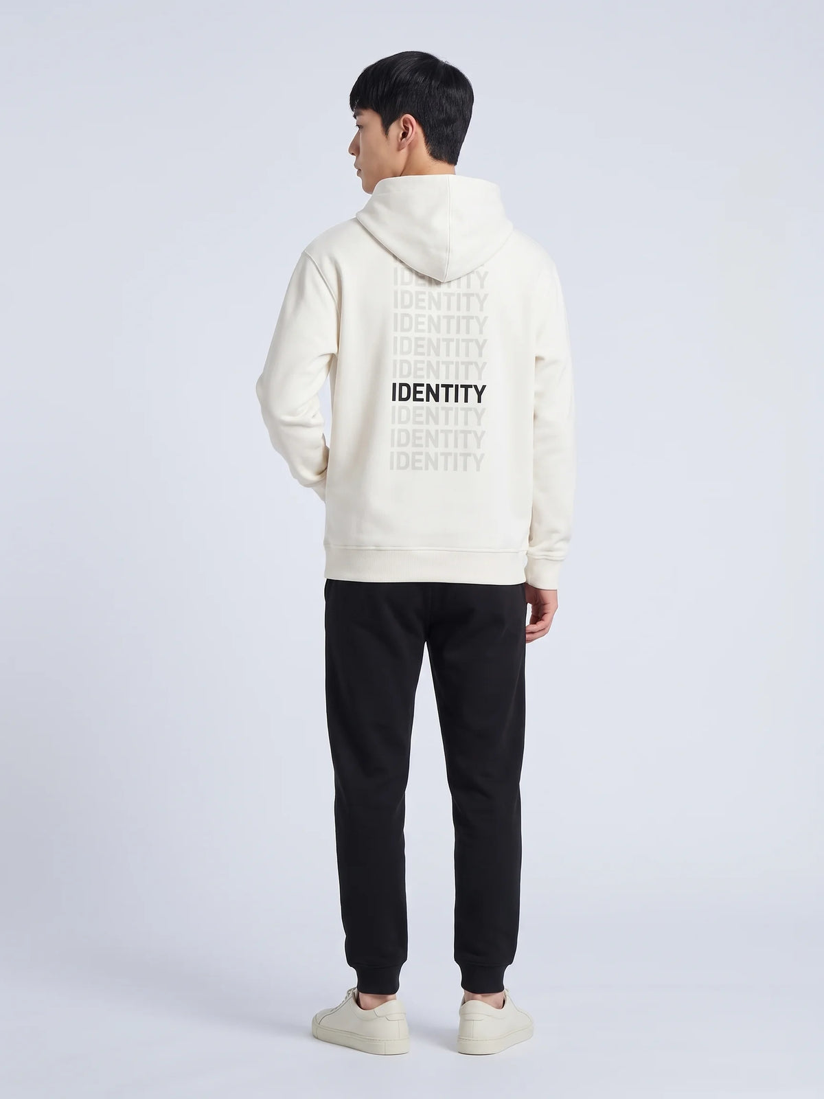 White heavyweight hoodie in organic cotton, Unidentity Identity Hoodie, back view of the IDENTITY print with black joggers, Dubai streetwear #color_white