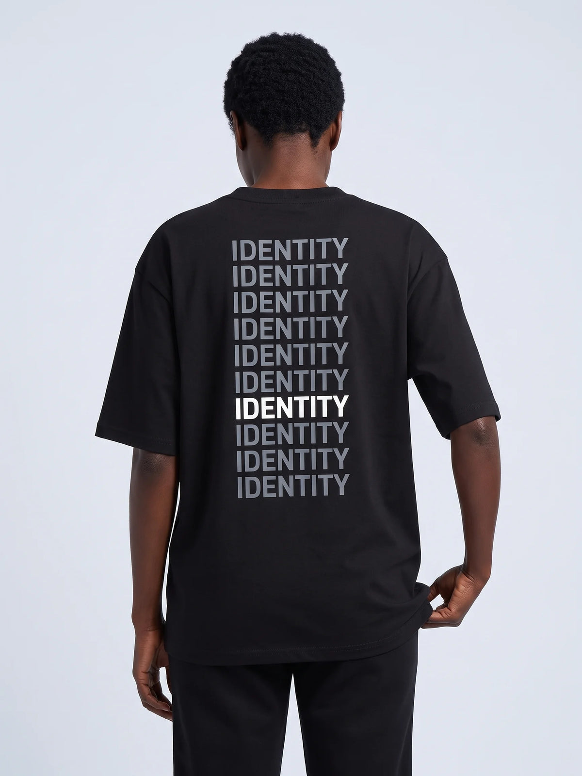 Black heavyweight oversized t-shirt in organic cotton, Unidentity Identity Tee, back close-up of the gray and white IDENTITY print, UAE streetwear #color_black