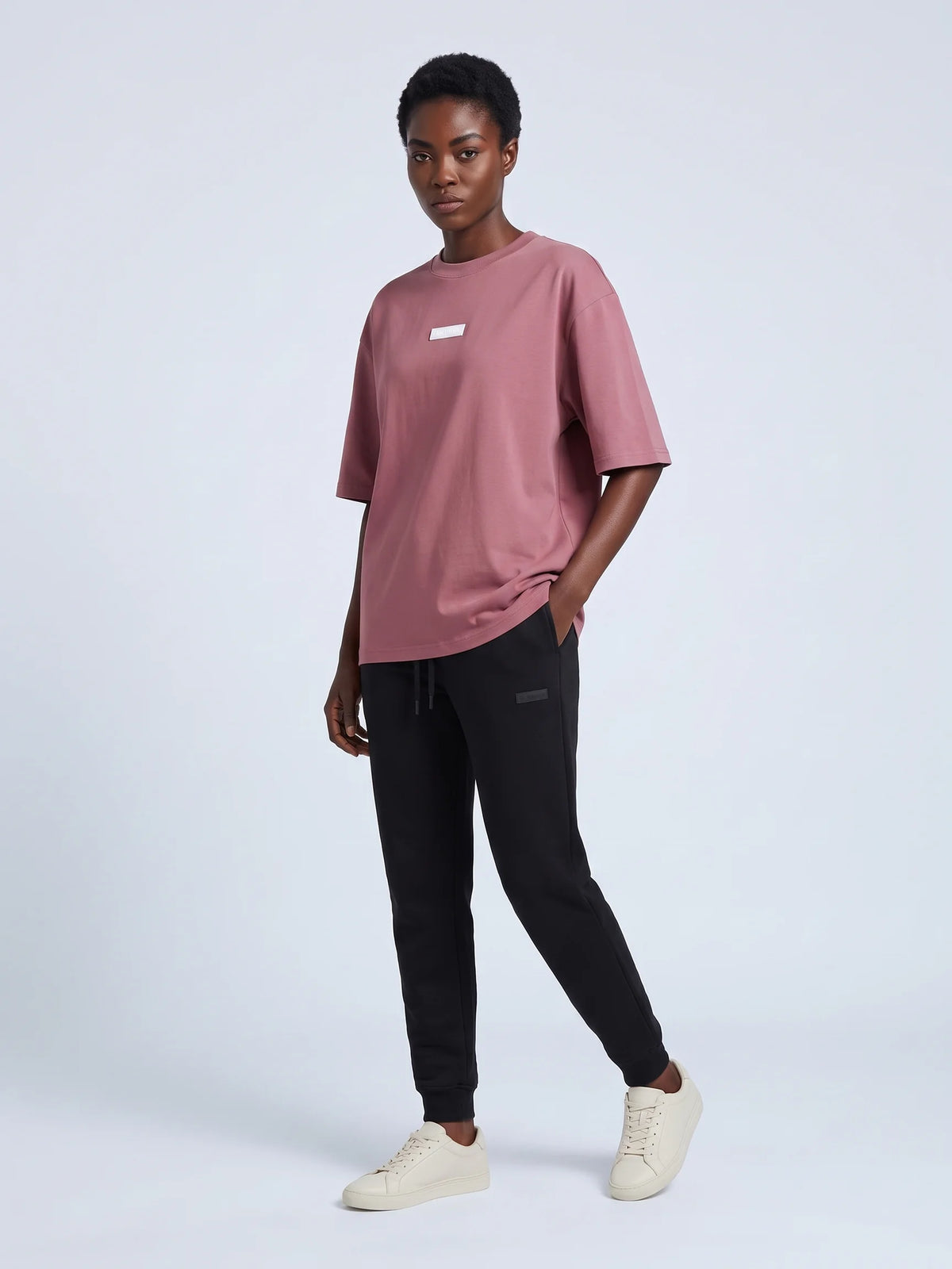 Plum oversized t-shirt in organic cotton, Unidentity Identity Tee, full-length front view worn by woman with black Core joggers, 210gsm #color_plum