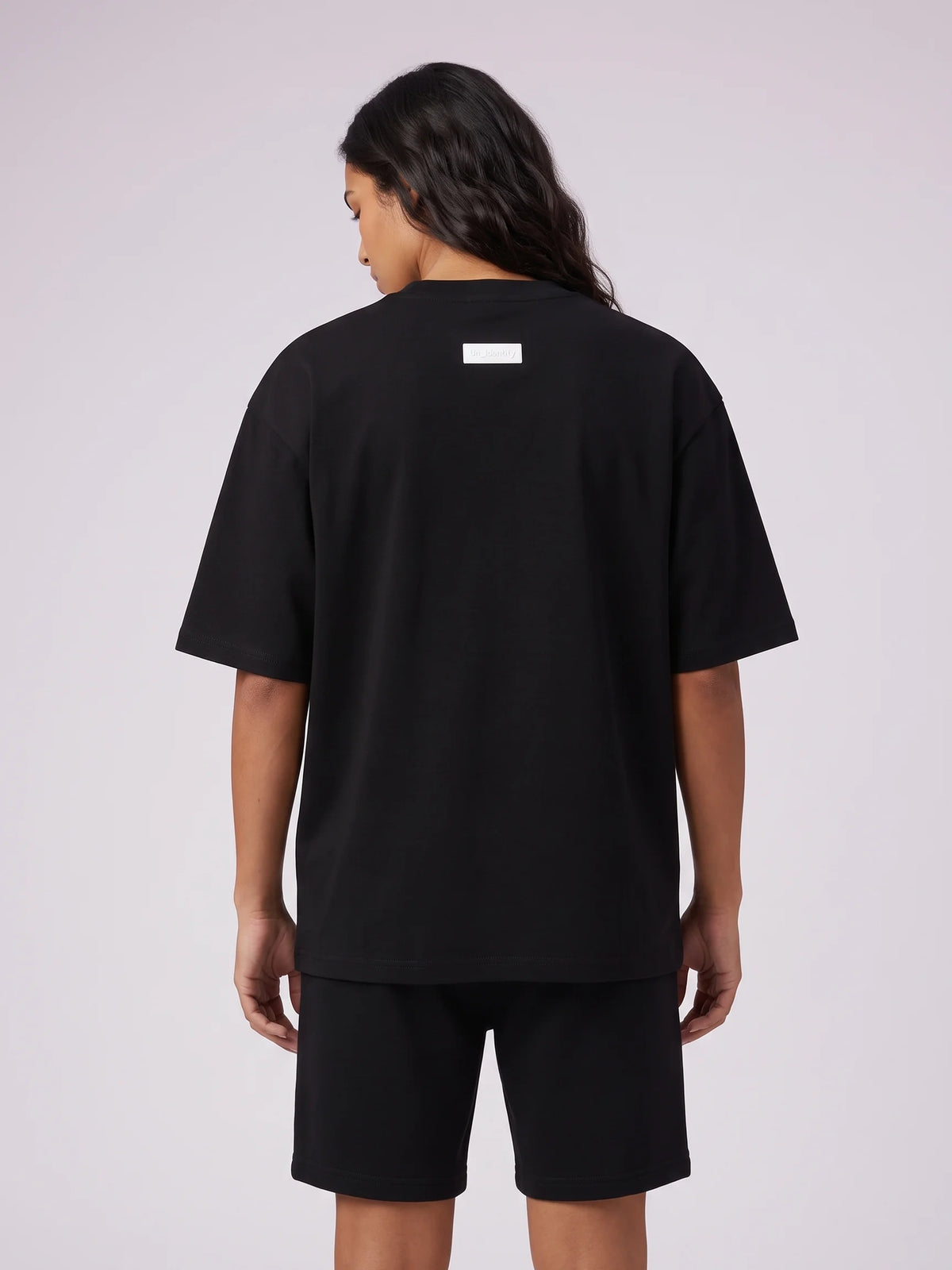 Black heavyweight oversized t-shirt in organic cotton, Unidentity Foundation Tee, back close-up of the white 3D patch, 210gsm UAE streetwear #color_black