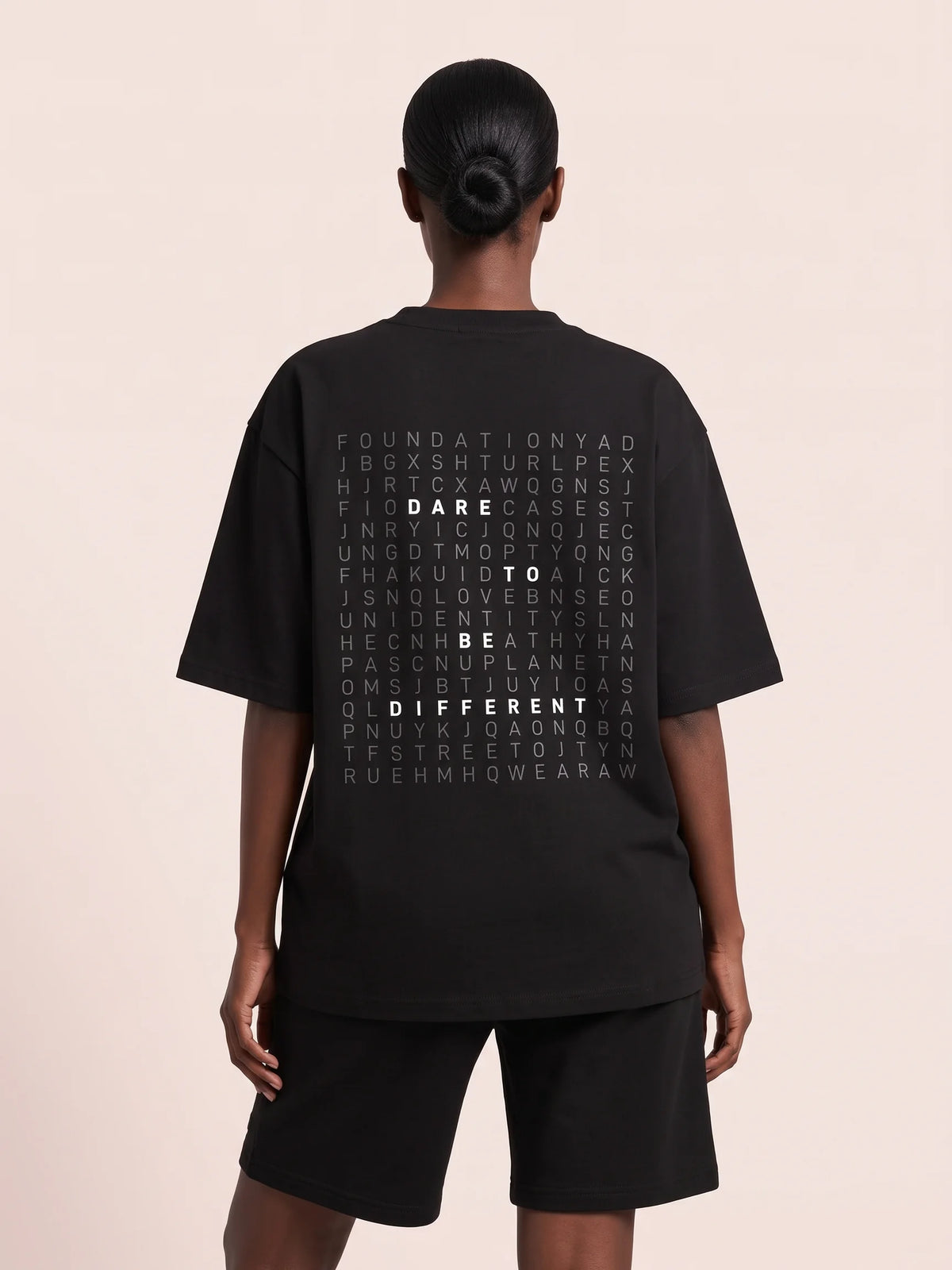 Black heavyweight oversized t-shirt in organic cotton, Unidentity Dare Tee, back view of the DARE TO BE DIFFERENT word search print, Dubai streetwear #color_black