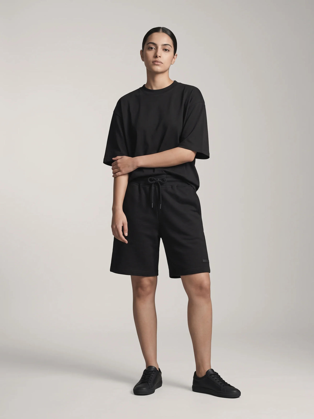 Black oversized t-shirt in organic cotton, Unidentity You Tee, full-length front view worn by woman showing the boxy fit, sustainable fashion #color_black