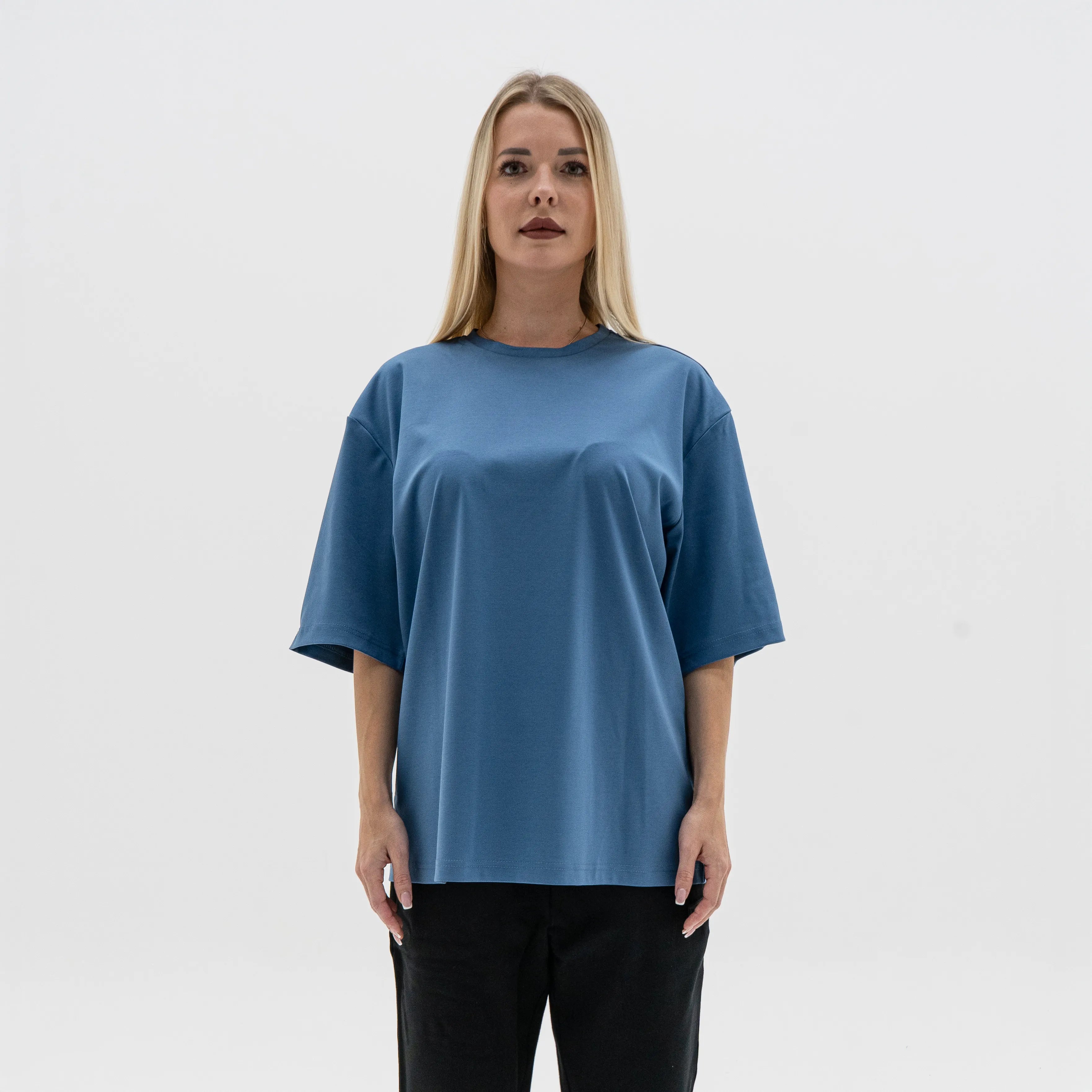 Woman wearing a blue oversized t-shirt against a white background. #color_blue