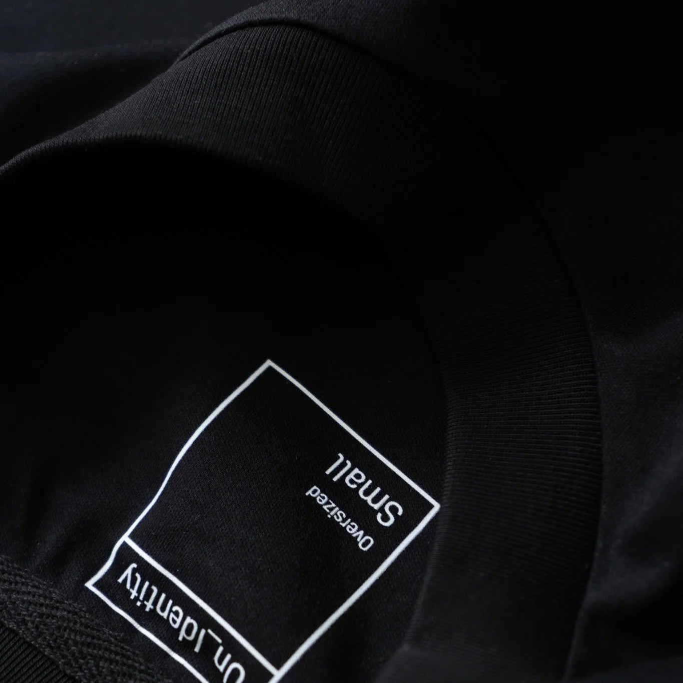 Black t-shirt with a label on the neck. #color_black