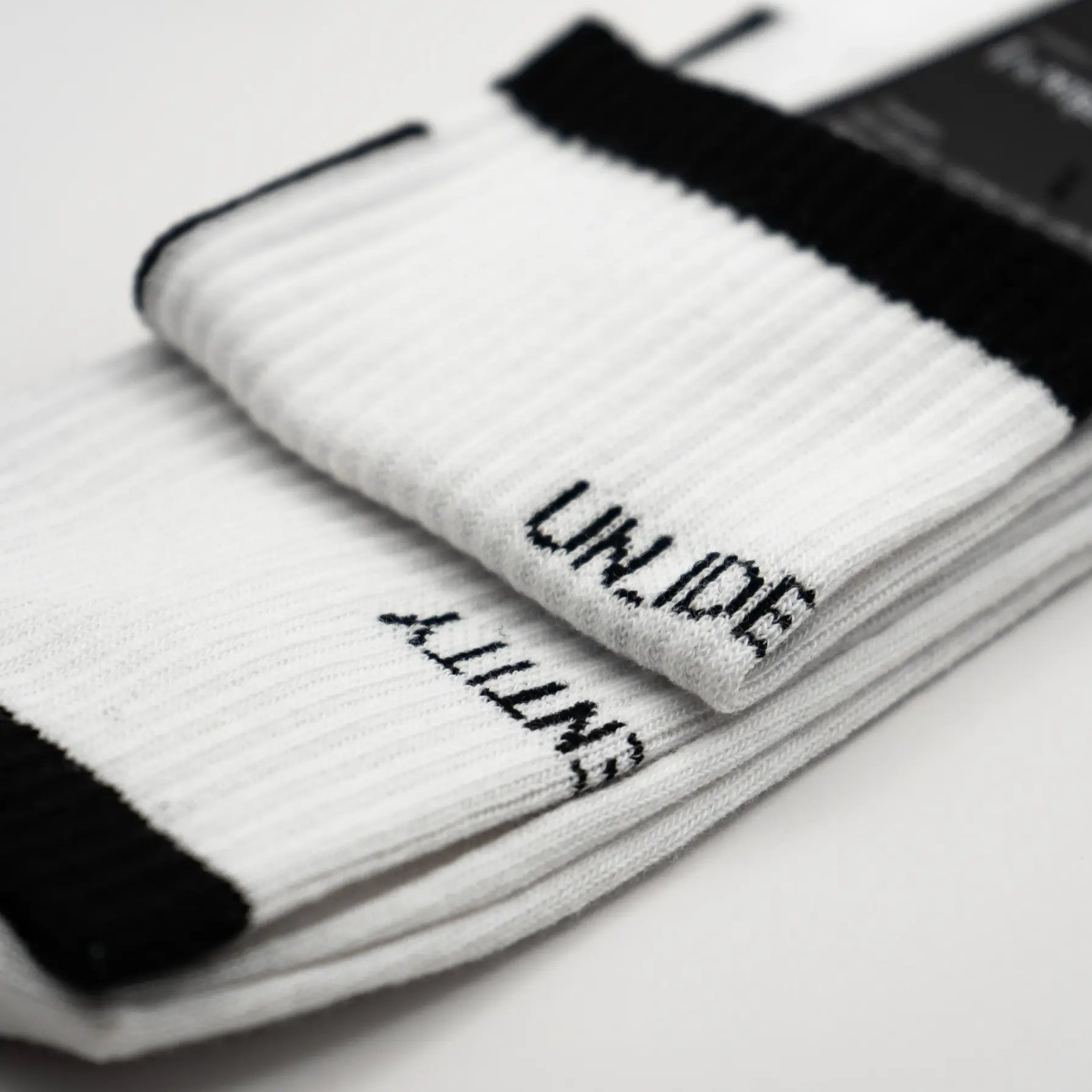White socks with black cuffs and black branding text