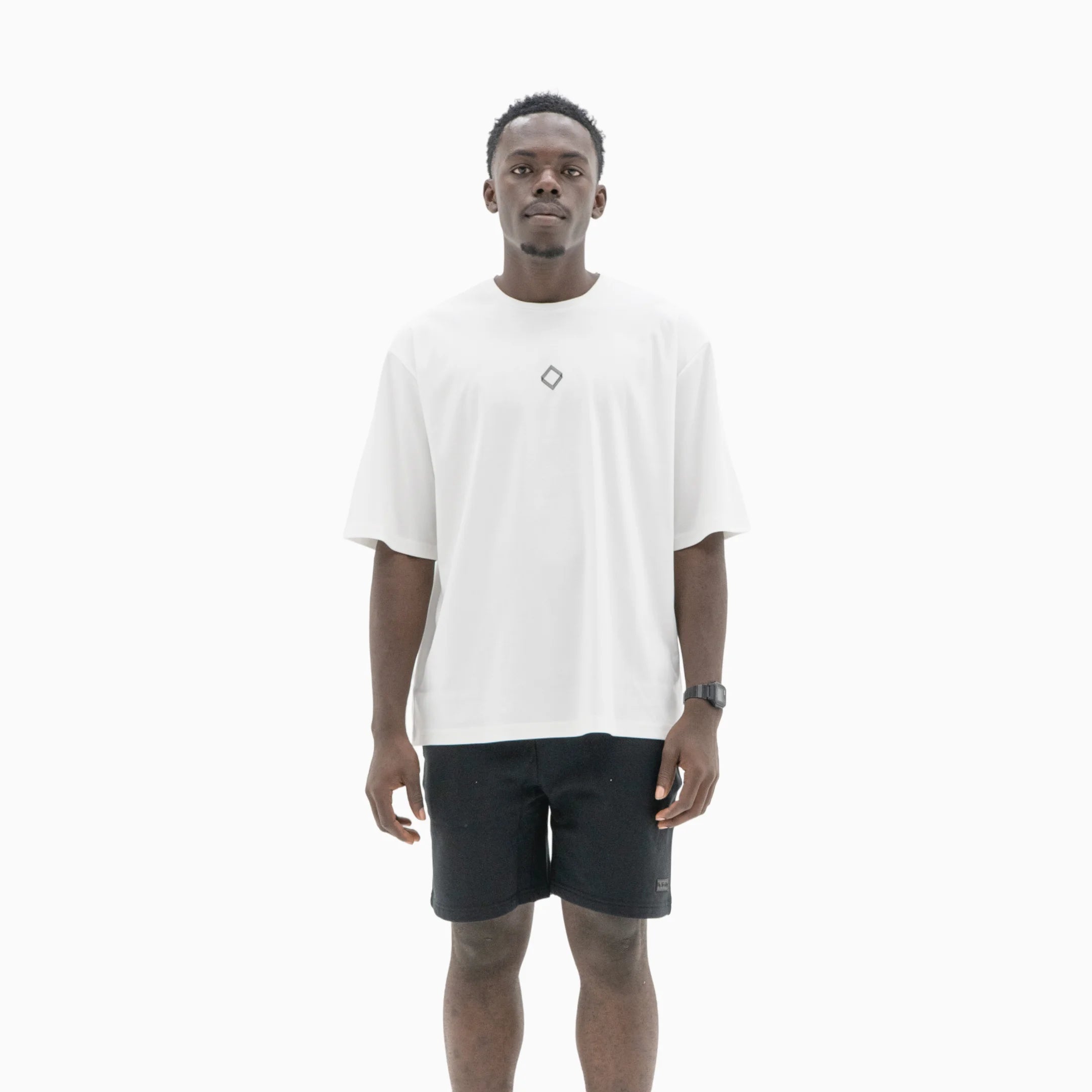 Person wearing a white t-shirt with a black logo on the chest against a plain background. #color_white