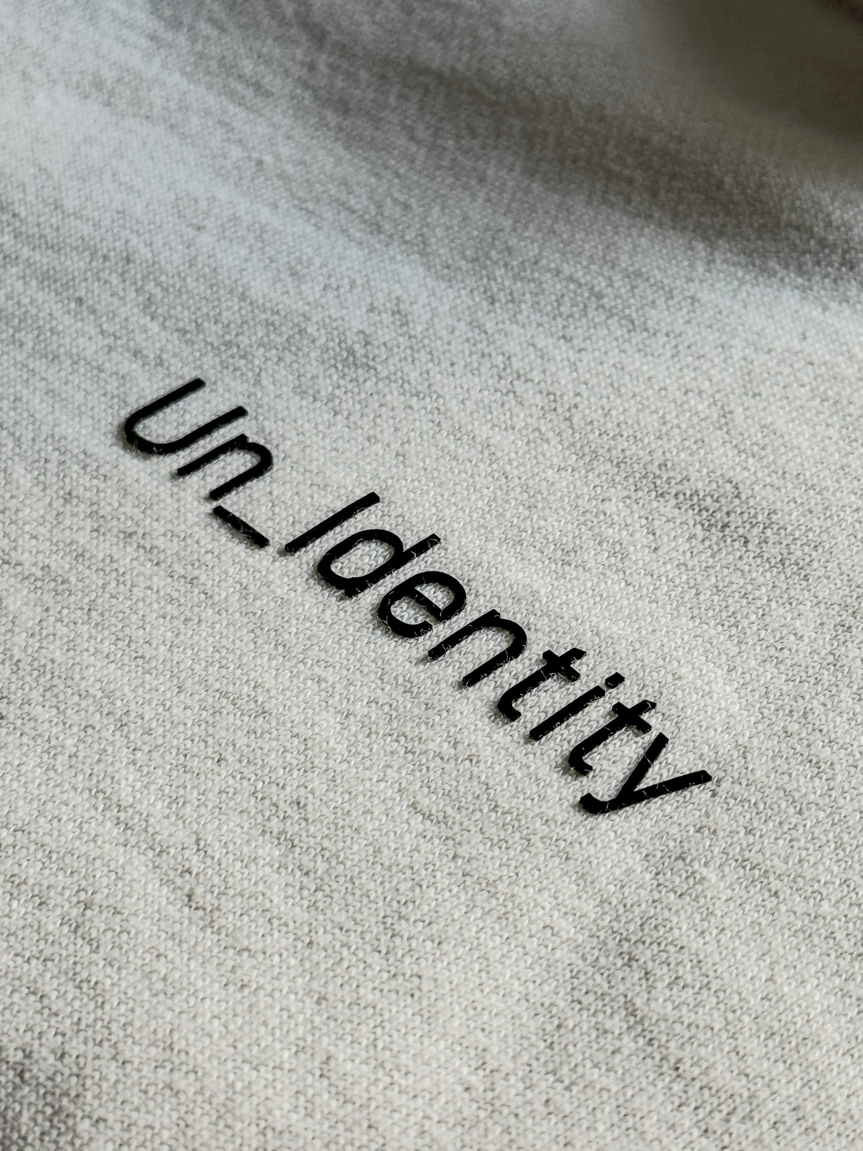 Text Unidentity embossed on a textured surface