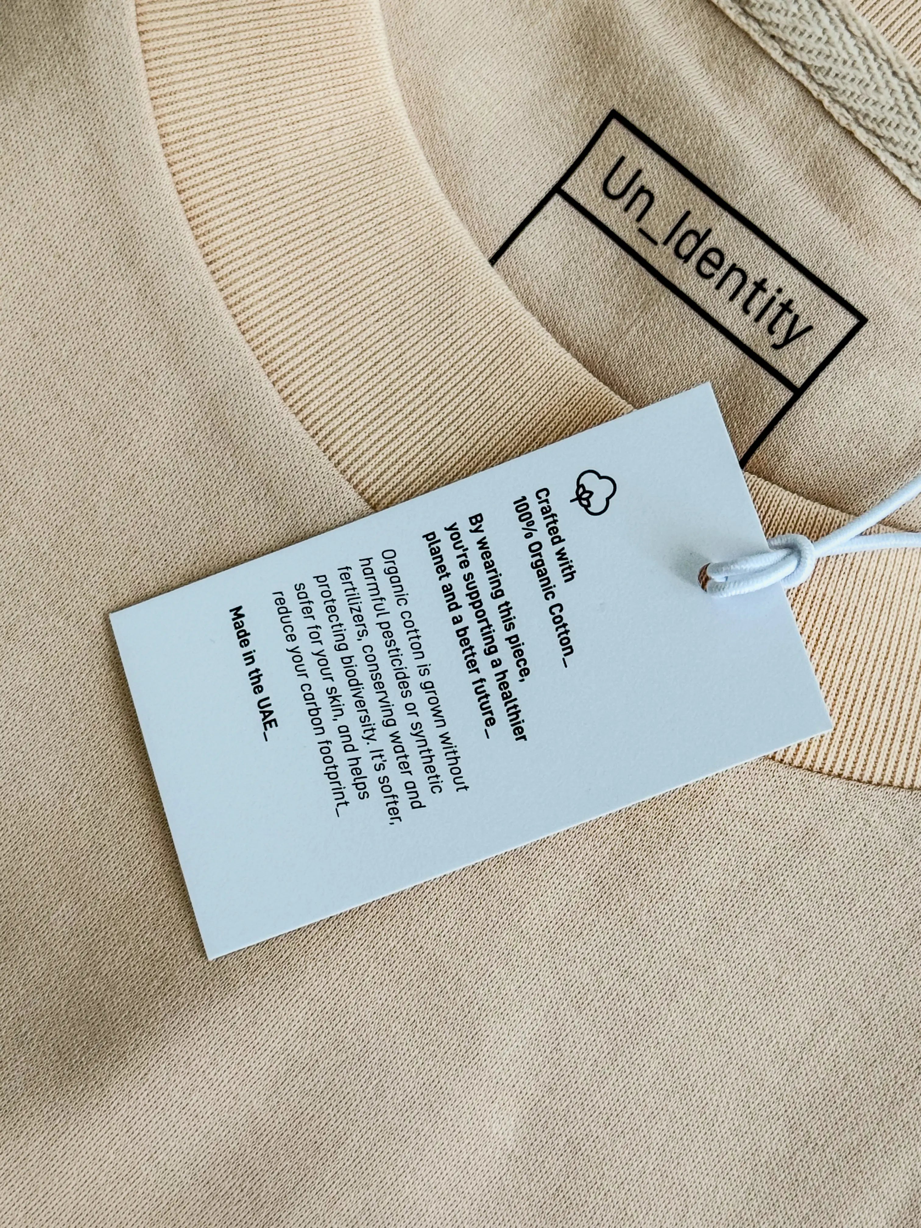Beige garment with Unidentity tag. #color_beige