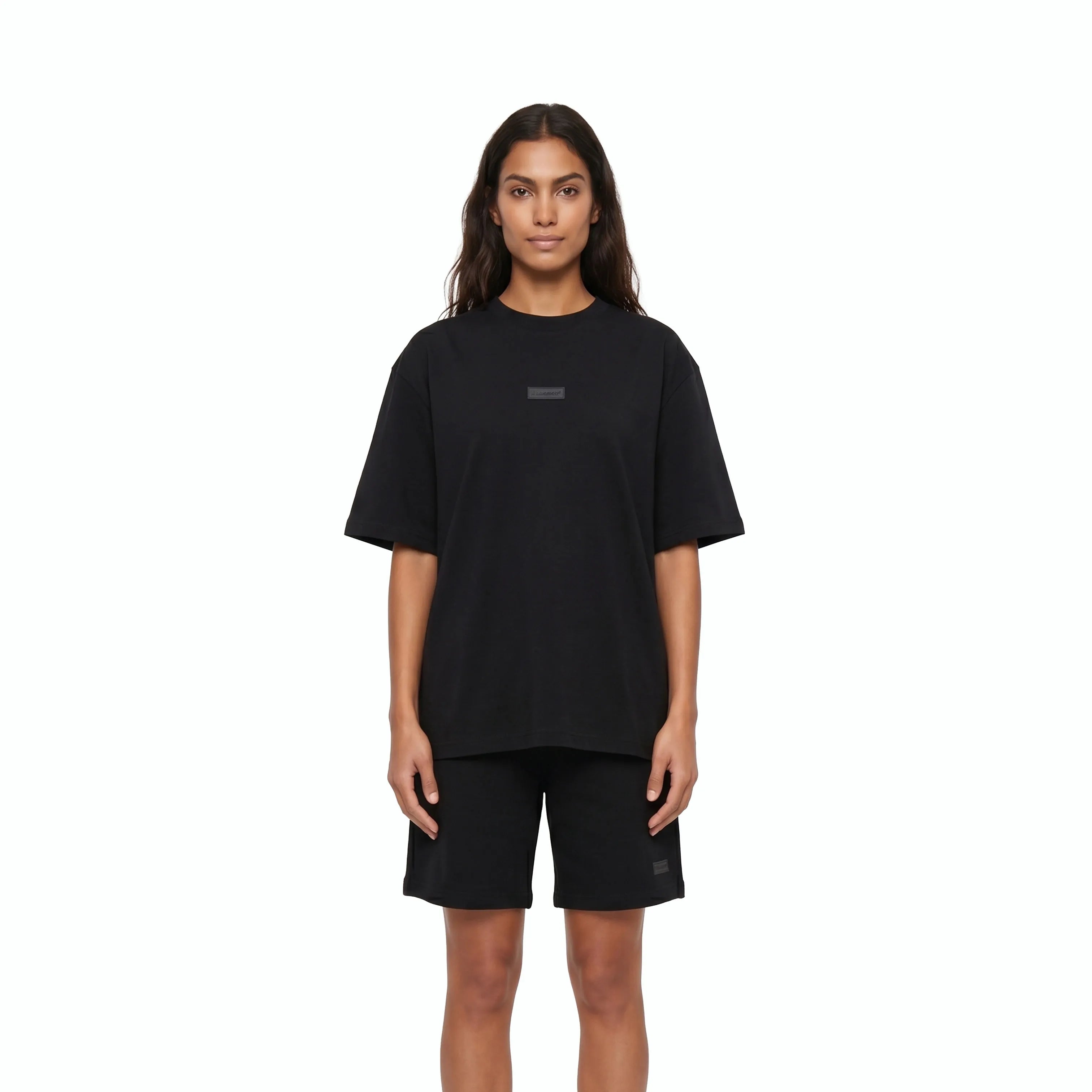 Woman wearing Unidentity black tee and black shorts. #color_black