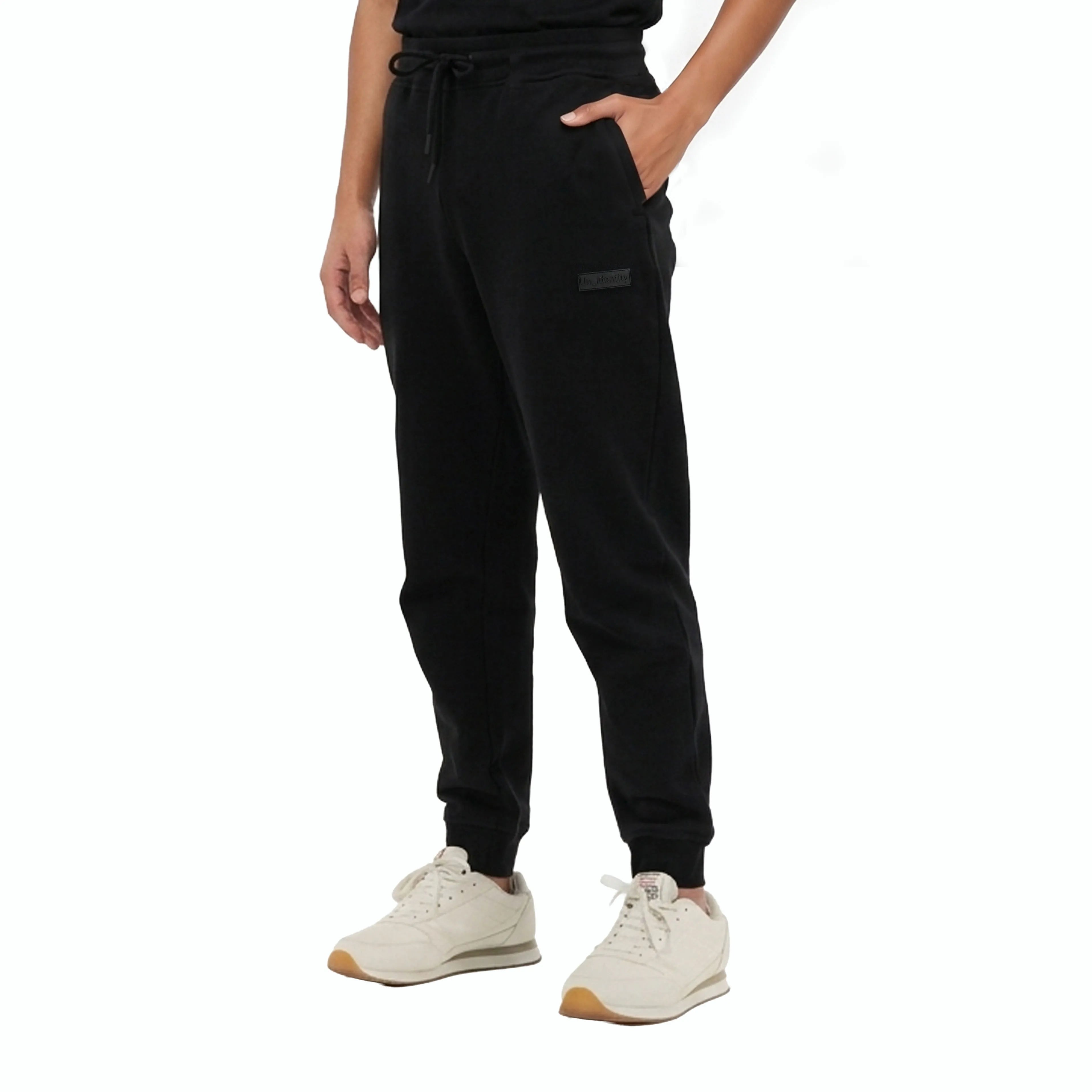 Person wearing black Unidentity jogger pants with drawstring and tonal logo