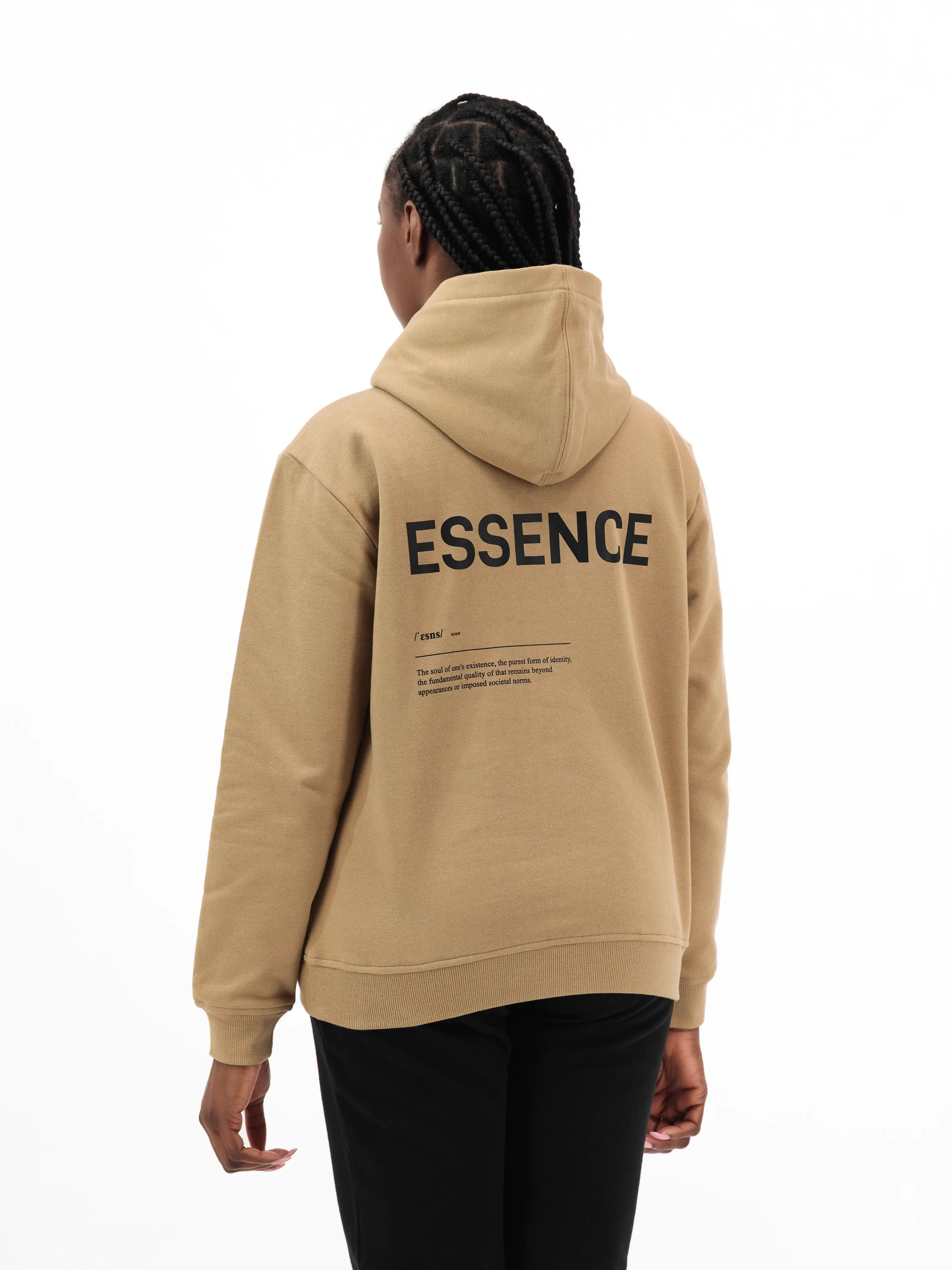 Person wearing beige hoodie with ESSENCE text on the back