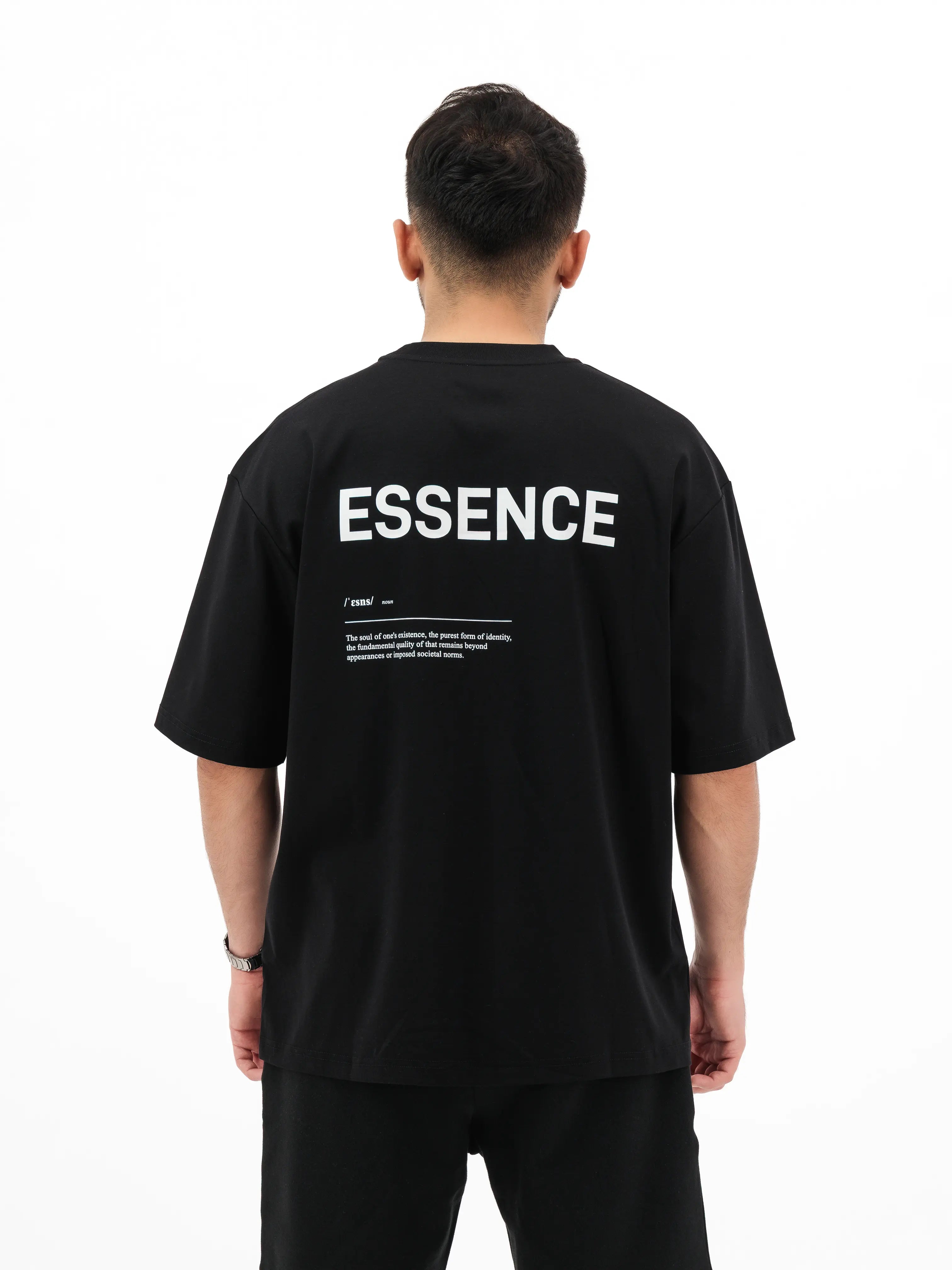 Man wearing black Unidentity T-shirt with ESSENCE printed on the back. #color_black