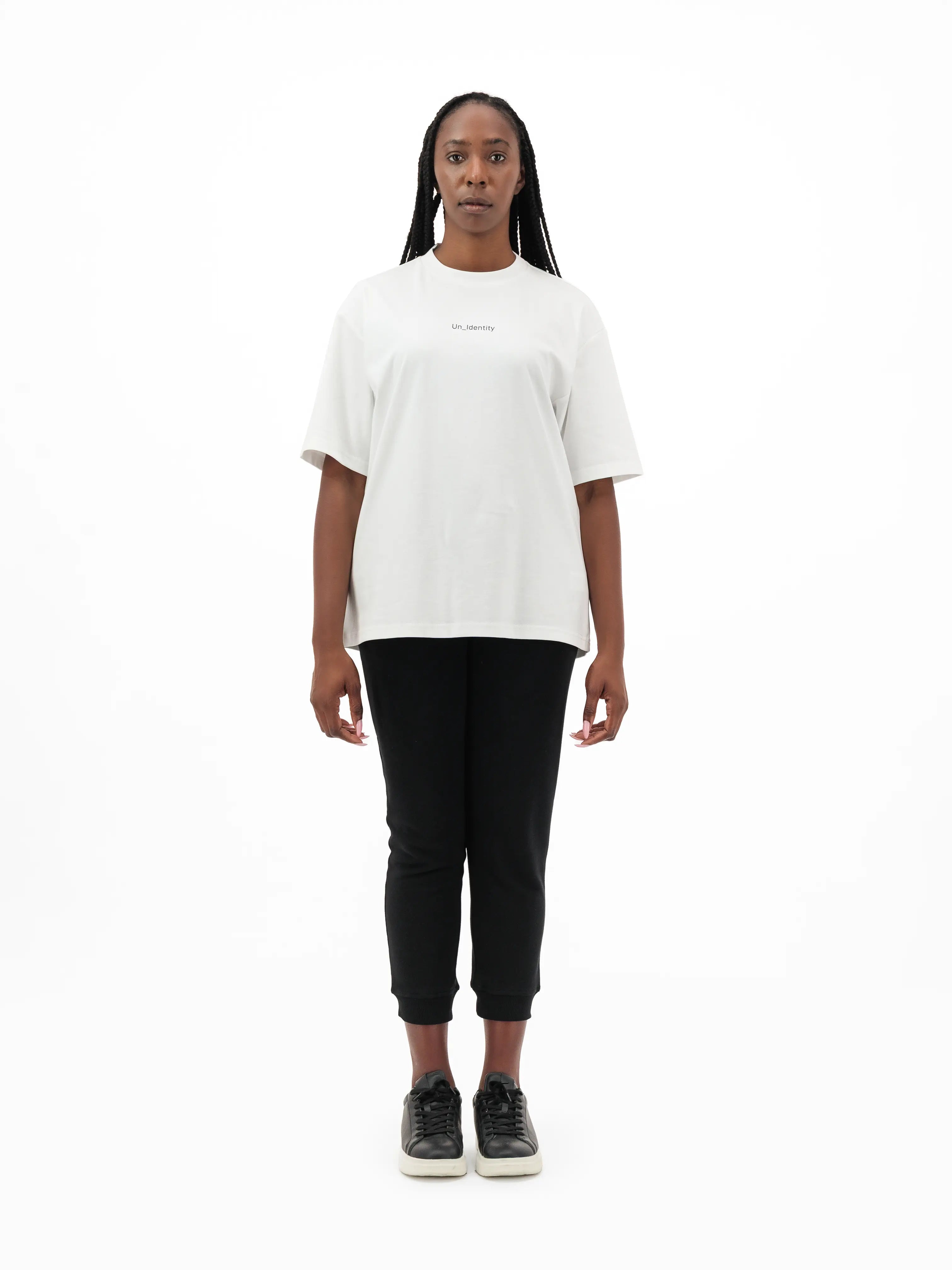 Model wearing white Unidentity tee and black pants. #color_white