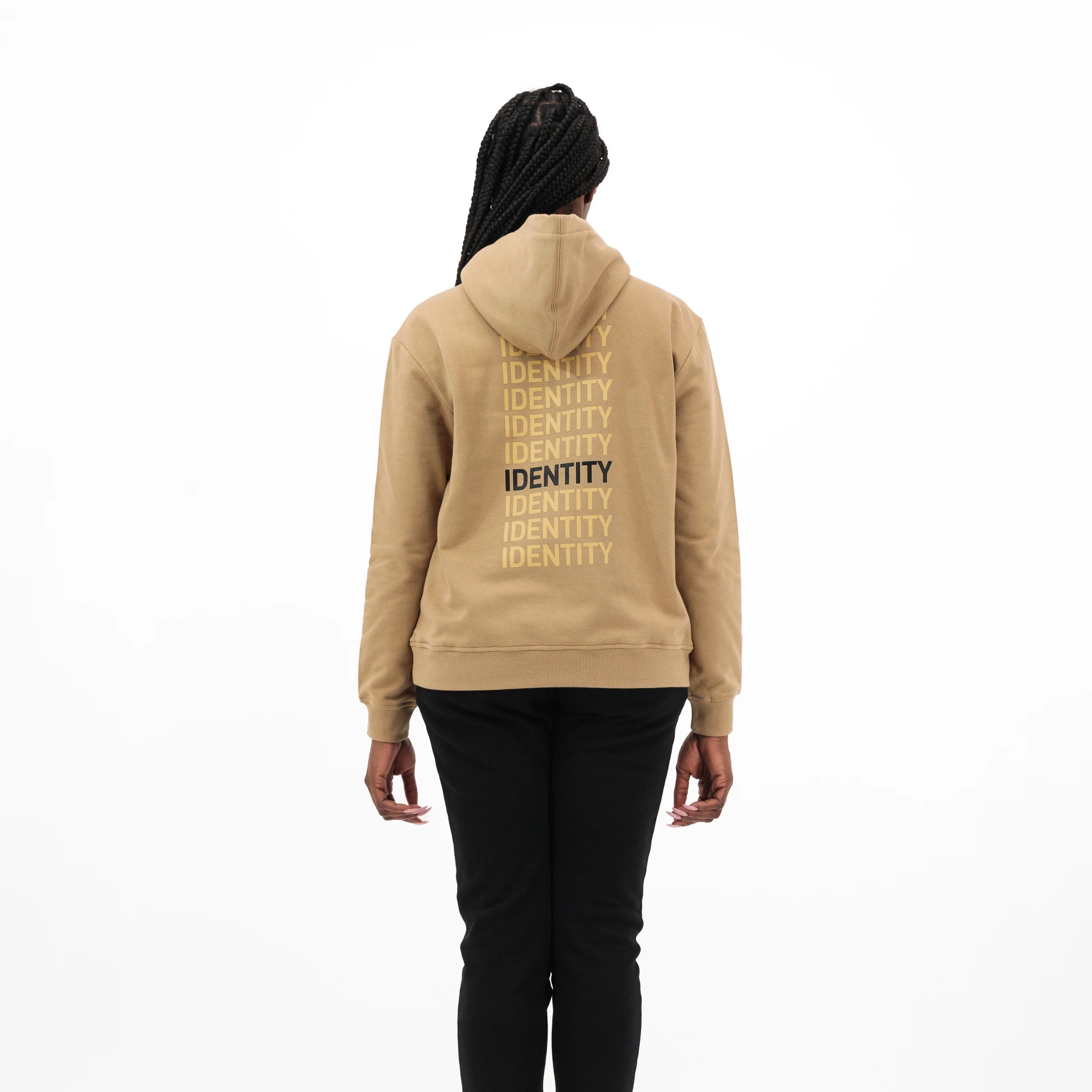 Person wearing beige hoodie with identity text vertically printed multiple times on the back. #color_beige