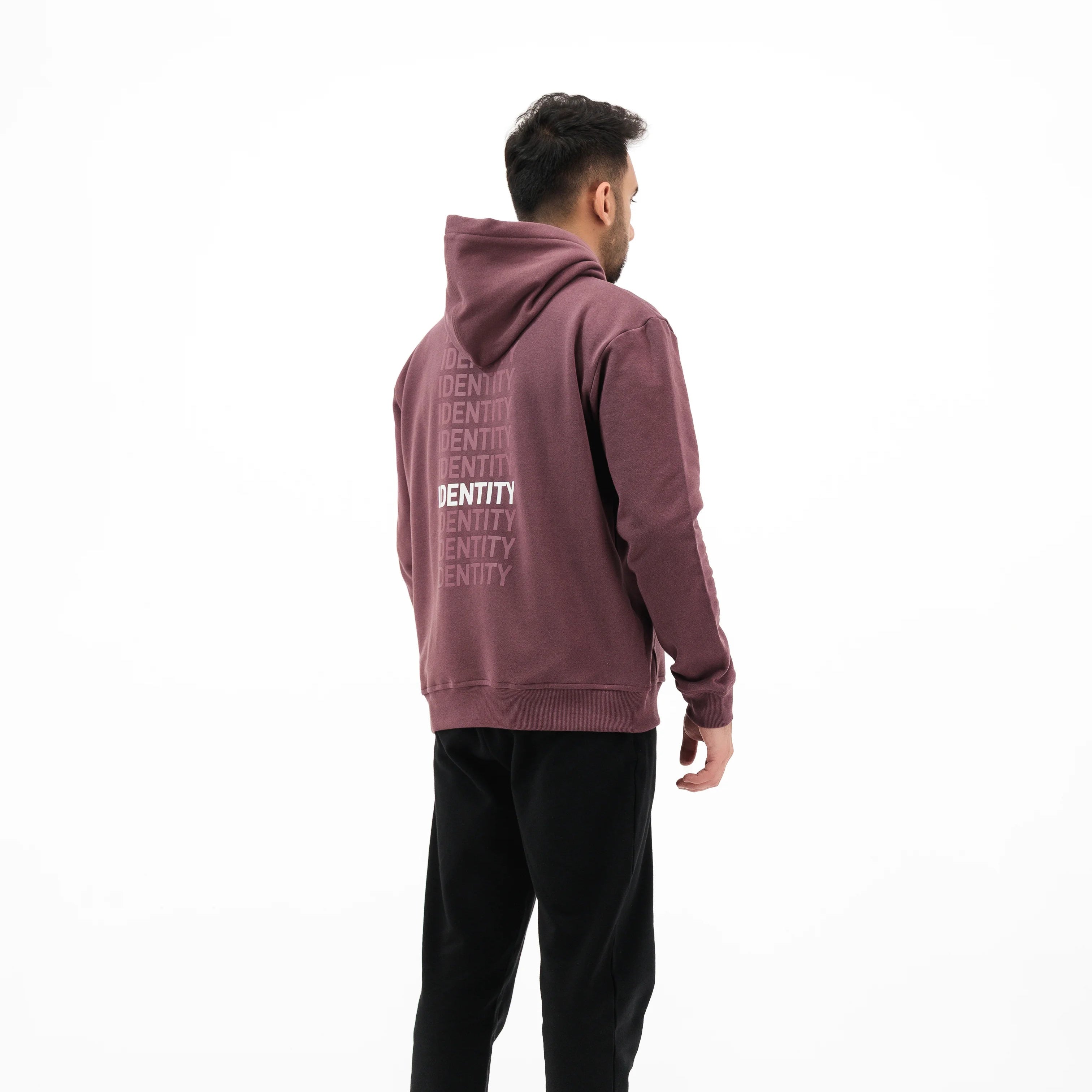 Model wearing mauve hoodie with text on the back. #color_plum