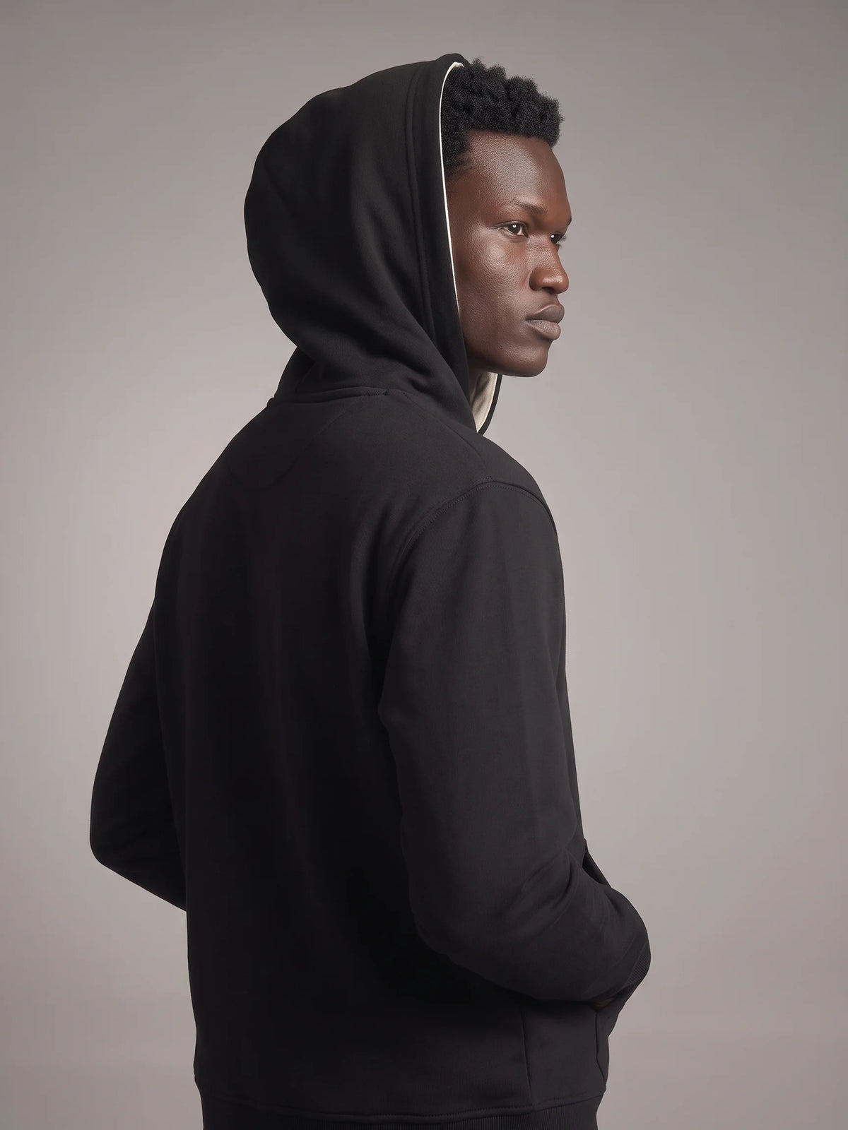 Black heavyweight hoodie in organic cotton, Unidentity Core Hoodie, back view over the shoulder on man with hood up, 390gsm #color_black