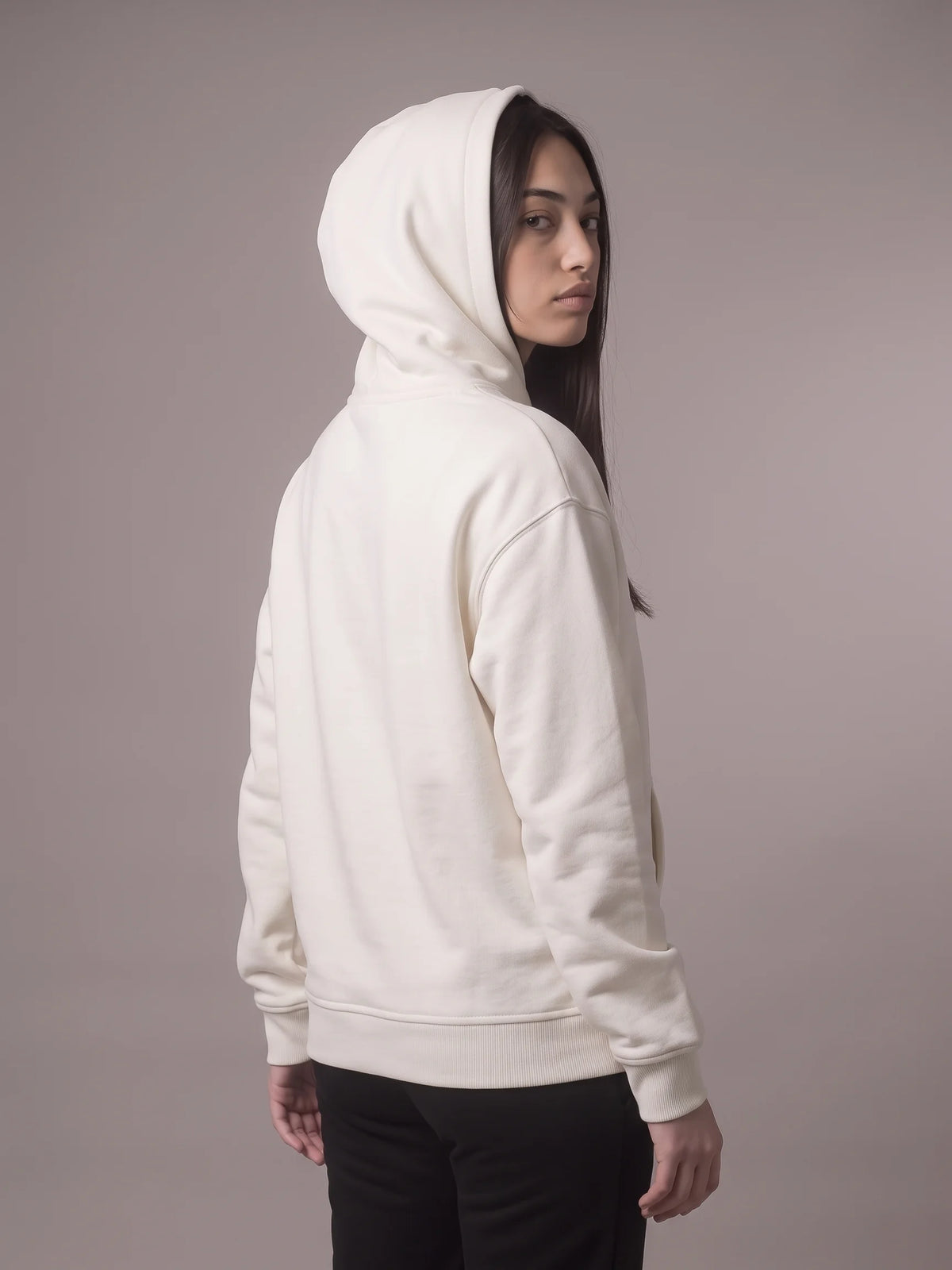 White organic cotton hoodie, Unidentity Core Hoodie, back view worn by woman with hood up, looking over her shoulder, UAE streetwear #color_white