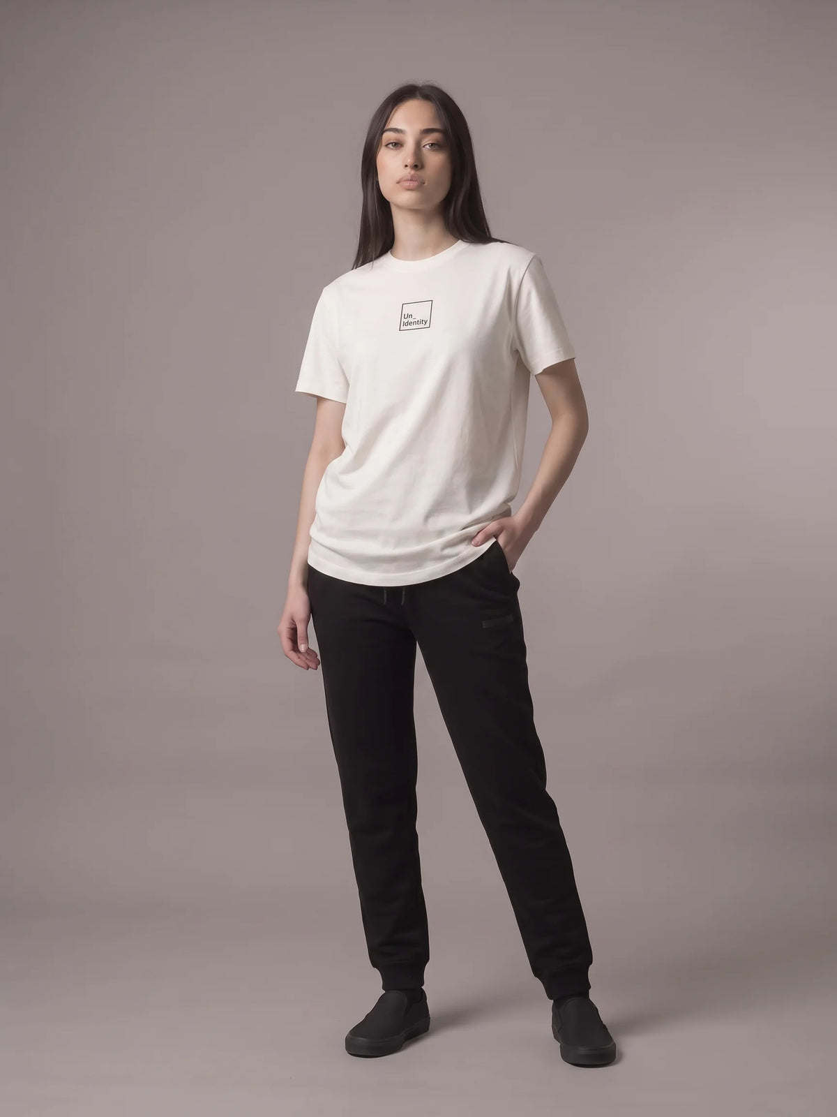 White organic cotton t-shirt, Unidentity Core Tee, full-length front view worn by woman, hand in pocket, with black Core joggers, streetwear #color_white