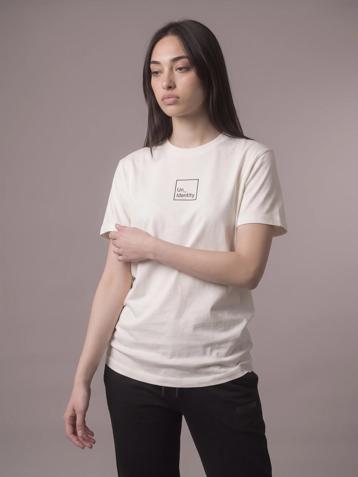 White organic cotton t-shirt, Unidentity Core Long Fit Tee, front three-quarter view worn by woman showing the minimal logo, 210gsm #color_white