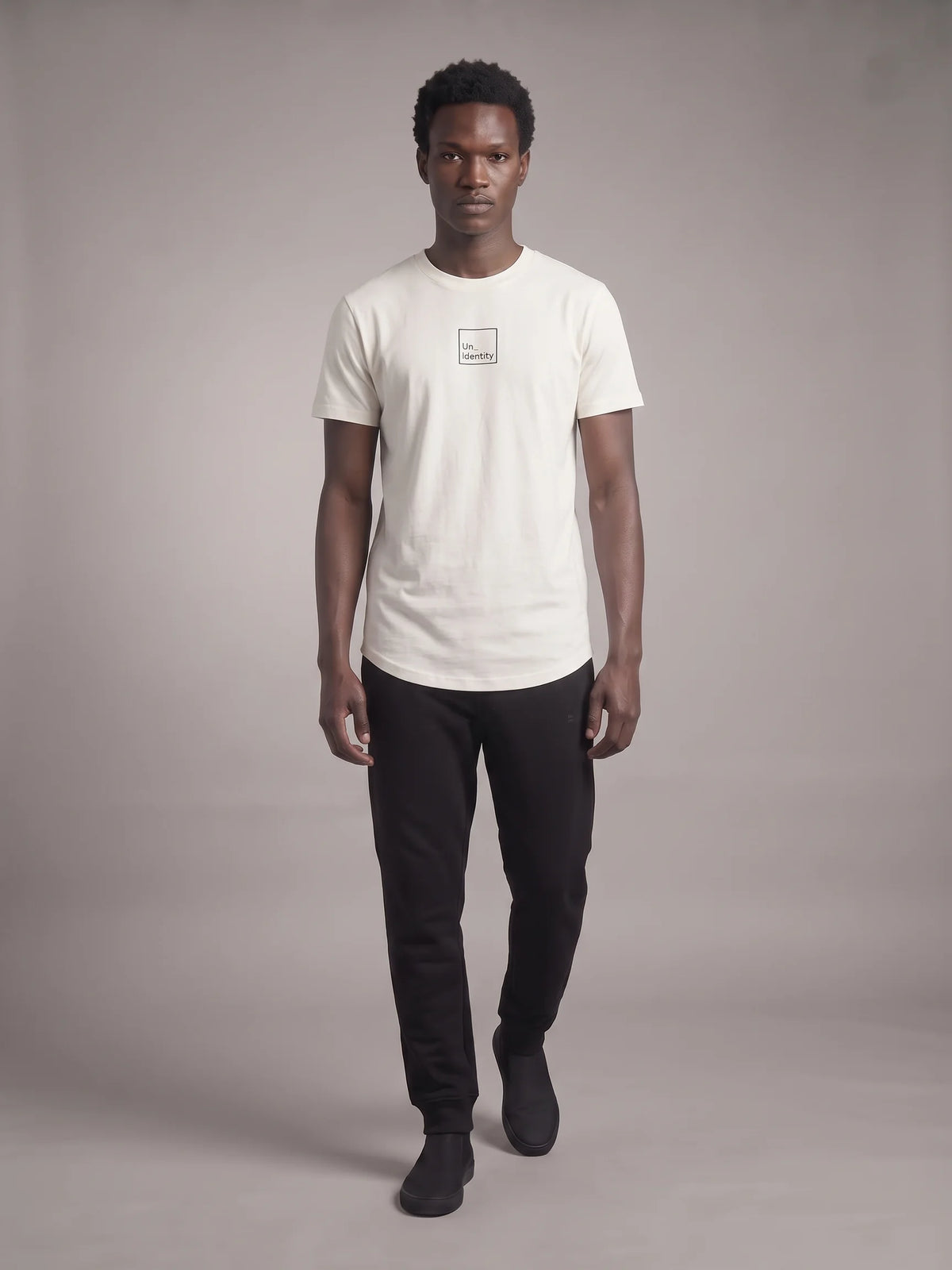 White long fit t-shirt, Unidentity Core Long Fit Tee, full-length front view on man with black Core Regular Fit Joggers, sustainable fashion #color_white