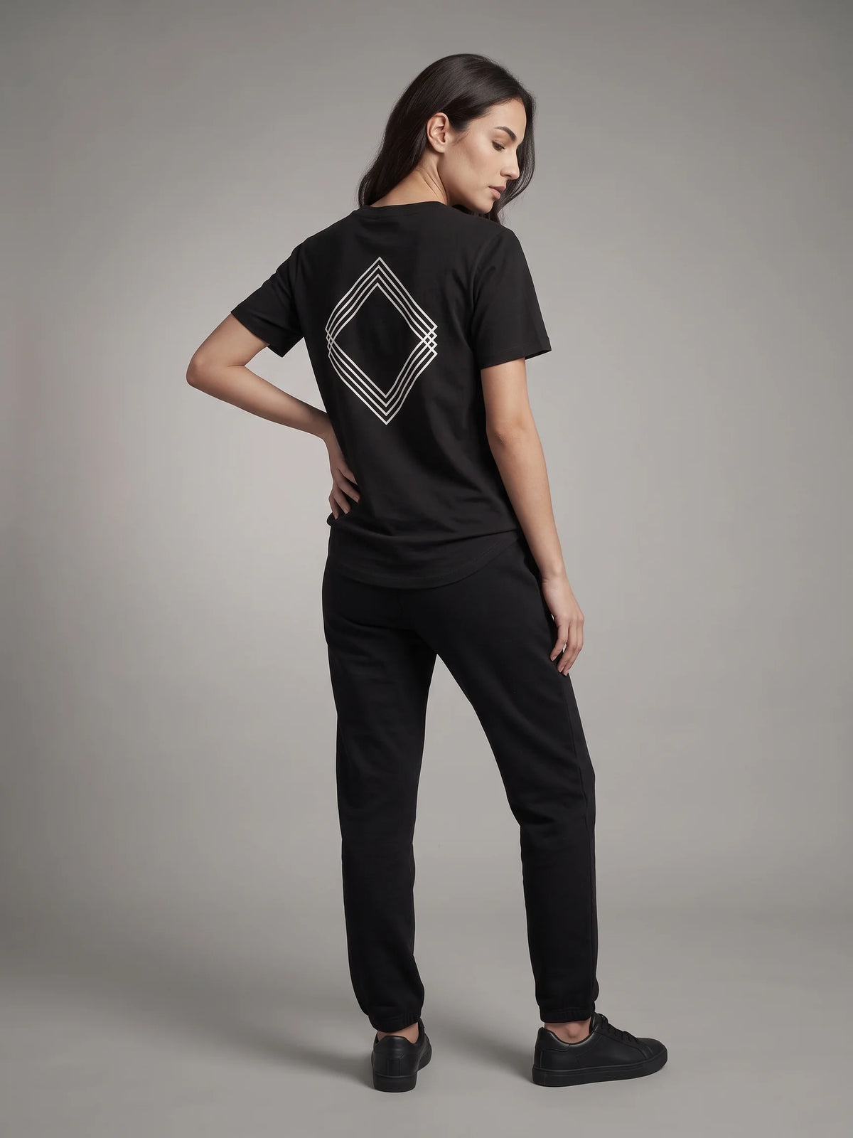 Black long fit t-shirt in organic cotton, Unidentity Gem Tee, full-length back view worn by woman showing the diamond logo, 210gsm #color_black