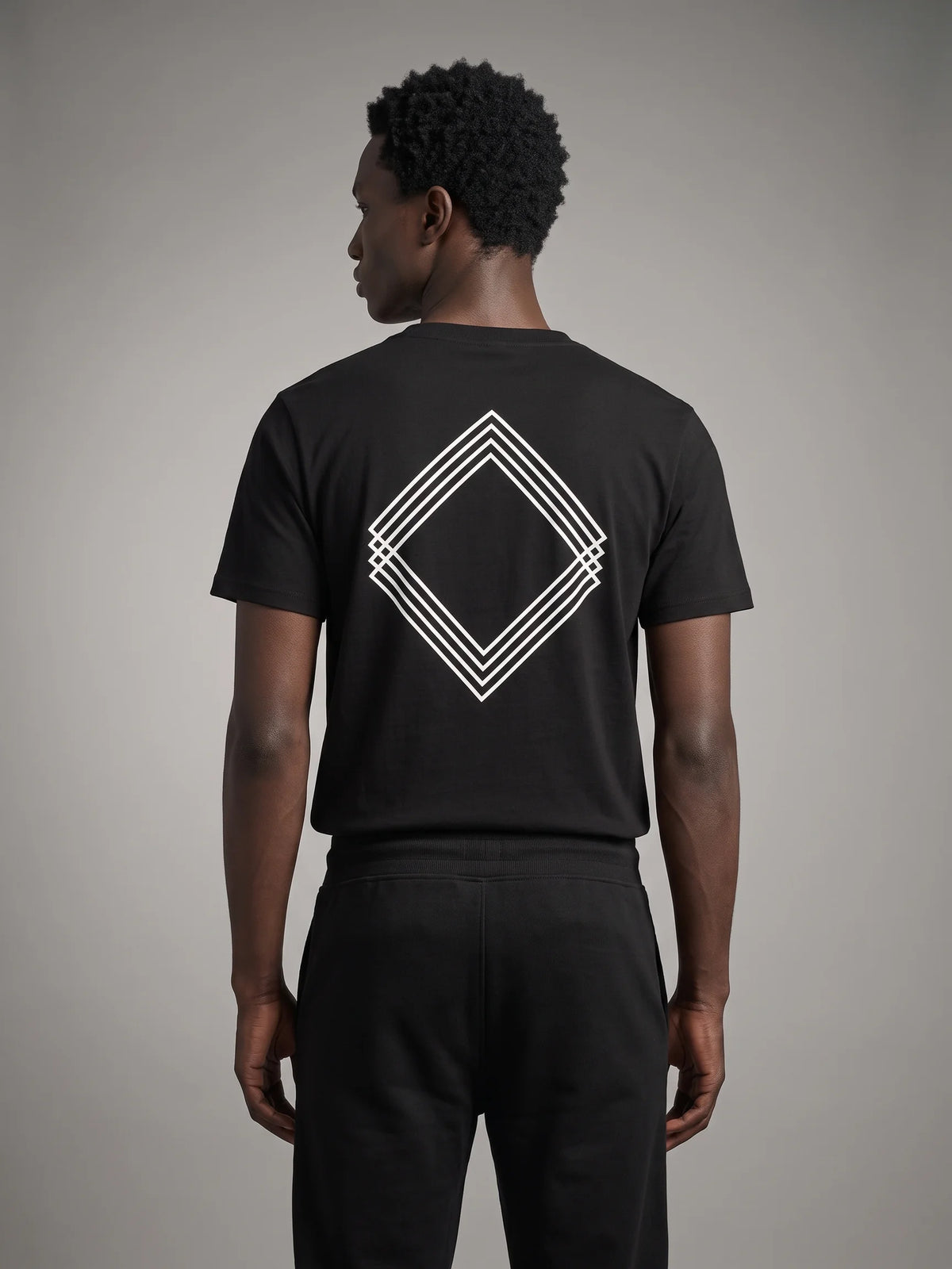 Black long fit t-shirt, Unidentity Gem Long Fit Tee, back view on man showing the white triple-line diamond logo, streetwear #color_black
