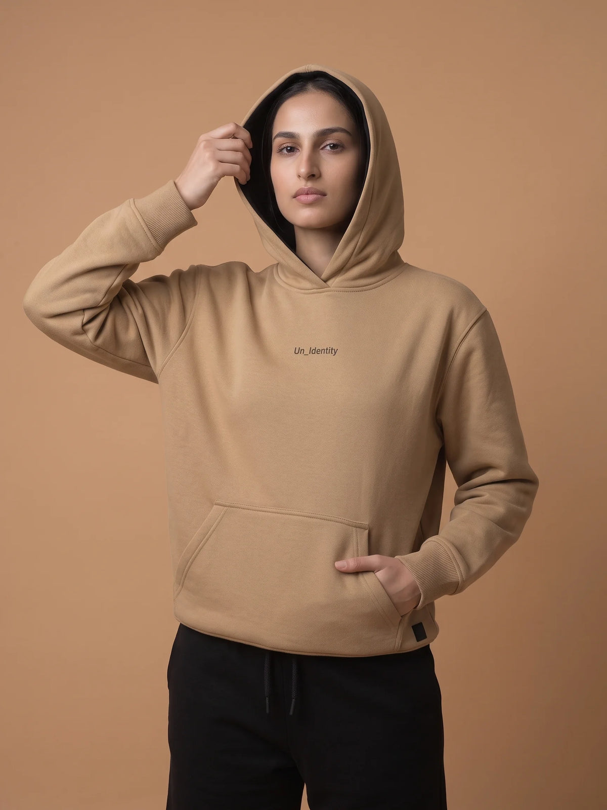 Beige organic cotton hoodie, Unidentity Soul Regular Fit Hoodie, front view worn by woman with hood up and hand in the kangaroo pocket, streetwear #color_beige