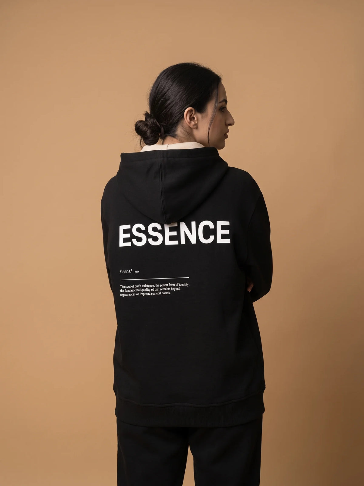 Black regular fit hoodie, Unidentity Soul Hoodie, back view of the white ESSENCE definition print and hood worn by woman, organic cotton #color_black
