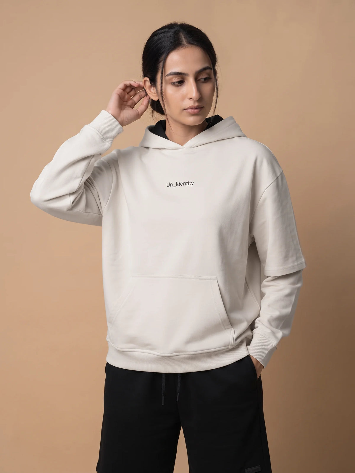 White organic cotton hoodie, Unidentity Soul Hoodie, front view of the chest logo and kangaroo pocket worn by woman, sustainable streetwear #color_white