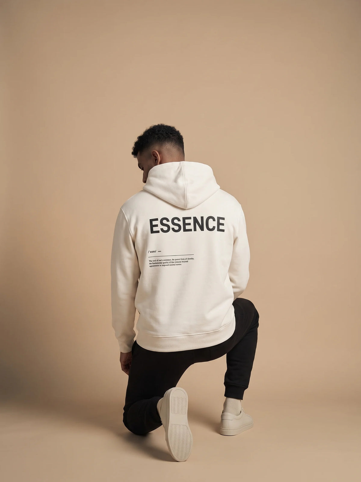 White regular fit hoodie, Unidentity Soul Hoodie, back view of the ESSENCE print worn by man kneeling with black Core joggers, 390gsm #color_white
