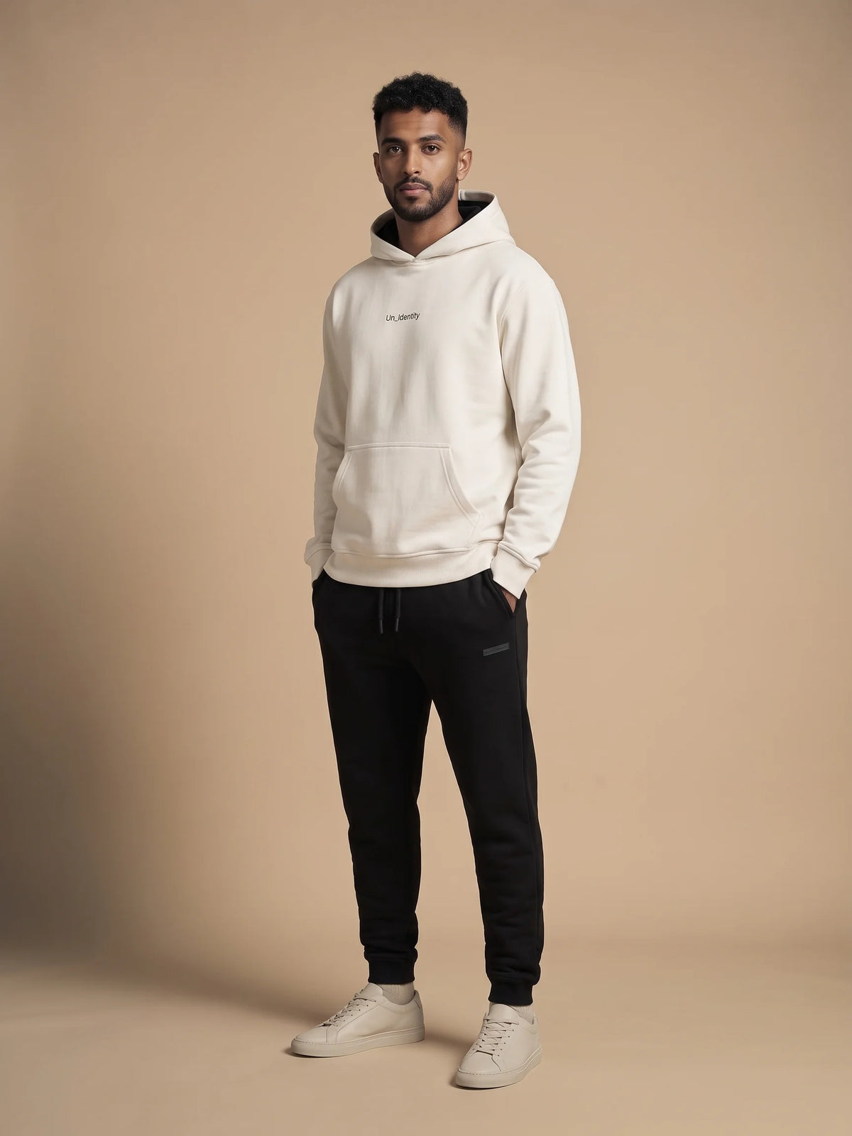 White organic cotton hoodie, Unidentity Soul Hoodie, full-length front view worn by man with hand in pocket and black Core joggers, streetwear #color_white