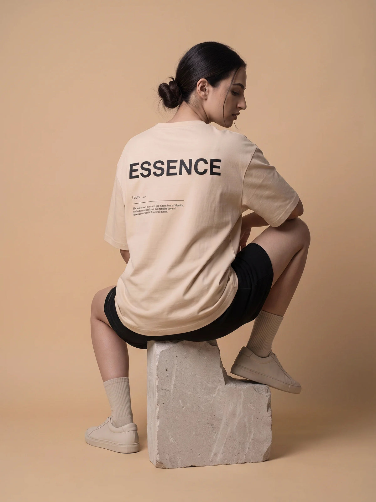 Beige heavyweight oversized t-shirt in organic cotton, Unidentity Soul Tee, back view of the ESSENCE print worn by woman, 210gsm streetwear from Dubai #color_beige