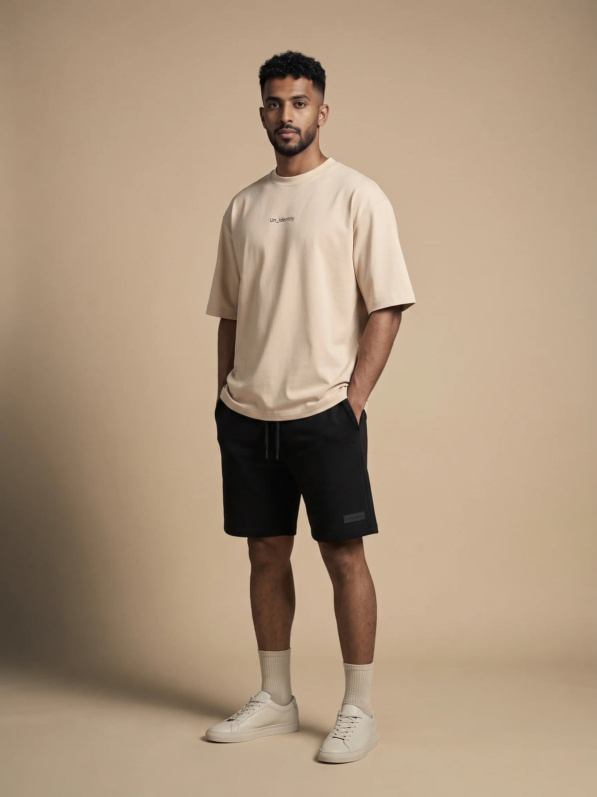 Beige oversized t-shirt, Unidentity Soul Oversized Tee, full-length front view on man styled with black Core shorts, UAE streetwear #color_beige