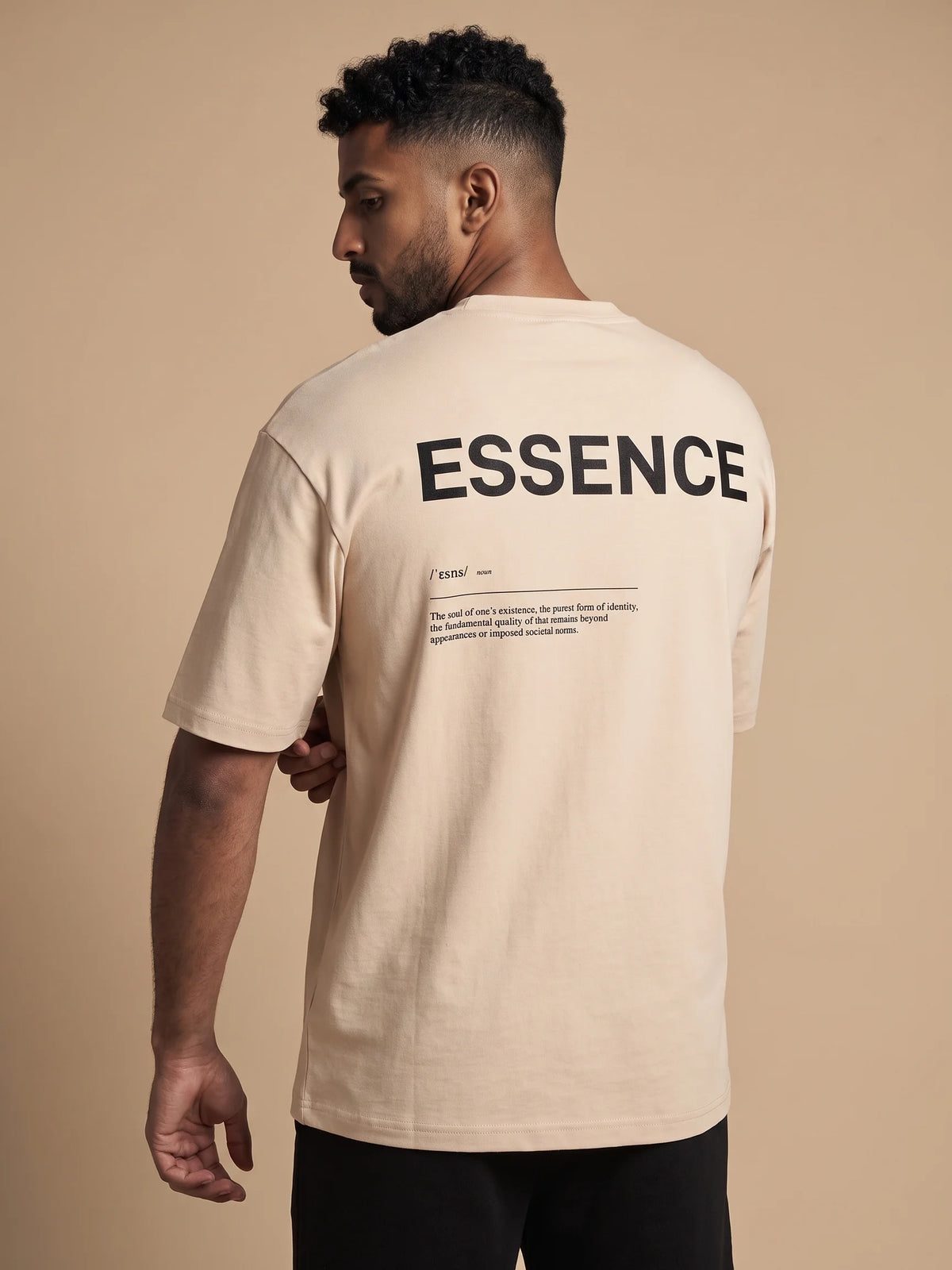 Beige oversized t-shirt, Unidentity Soul Oversized Tee, close-up back view of the black ESSENCE definition print worn by man, organic cotton #color_beige