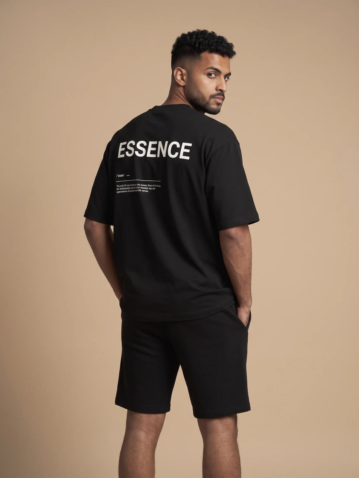 Black oversized t-shirt, Unidentity Soul Oversized Tee, back view of the ESSENCE print worn by man with black Core shorts, 210gsm #color_black
