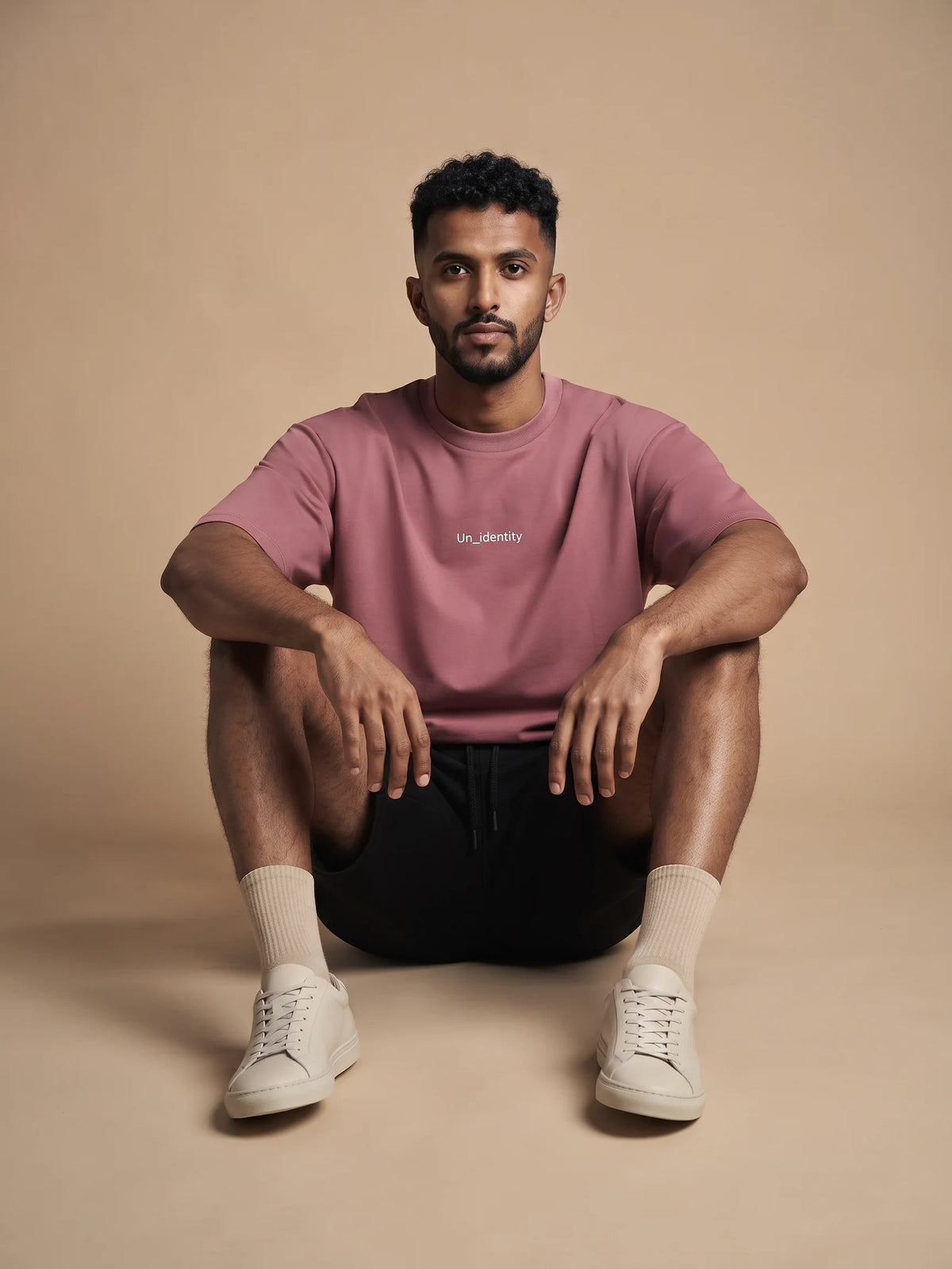 Plum heavyweight oversized t-shirt, Unidentity Soul Tee, front view of the relaxed fit and chest logo worn by man seated on the floor, organic cotton #color_plum