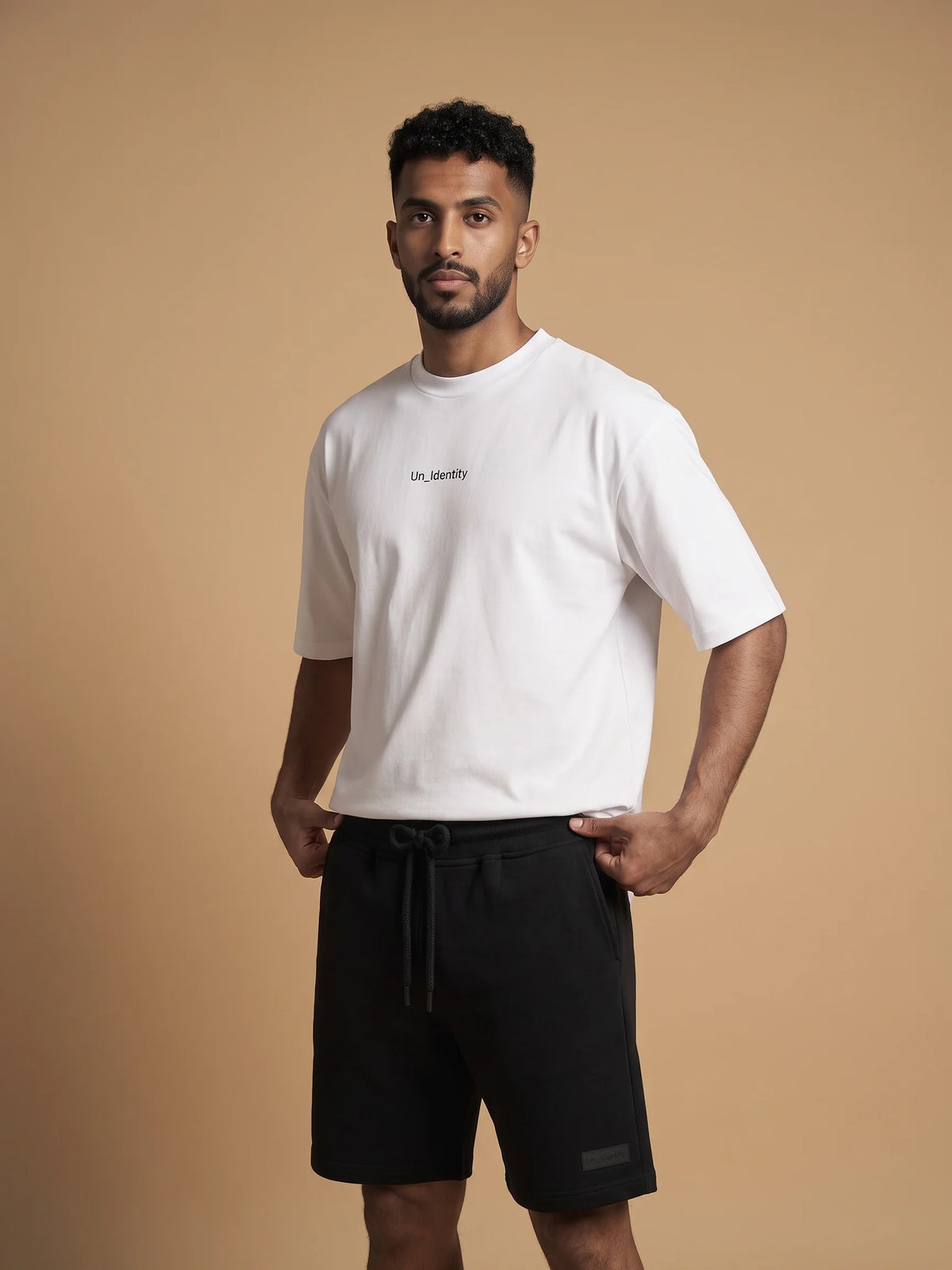 White heavyweight oversized t-shirt, Unidentity Soul Tee, three-quarter view of the chest logo on man with black Core shorts, sustainable fashion #color_white