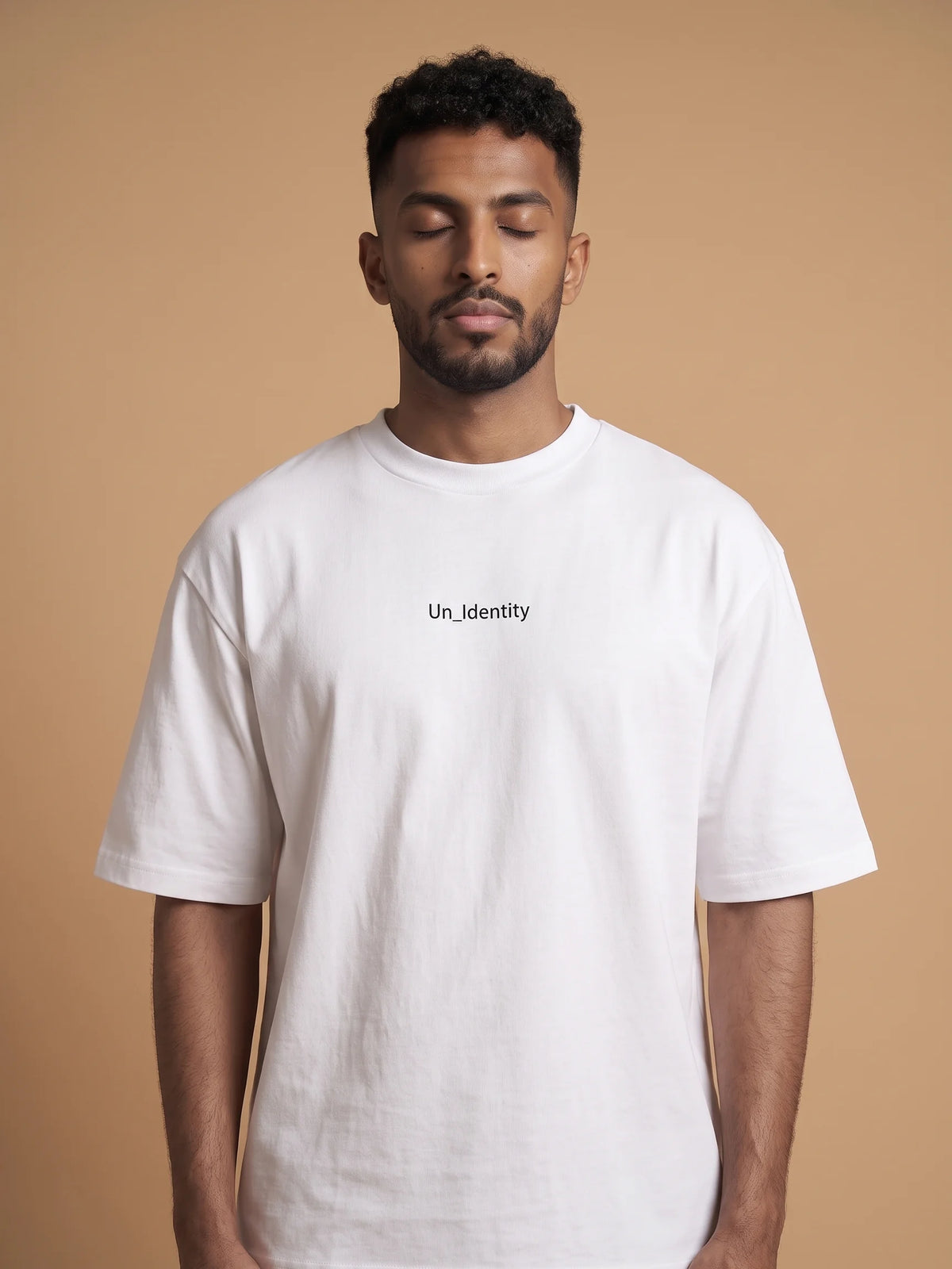 White organic cotton t-shirt, Unidentity Soul Oversized Tee, front close-up of the minimal chest logo worn by man, 210gsm #color_white