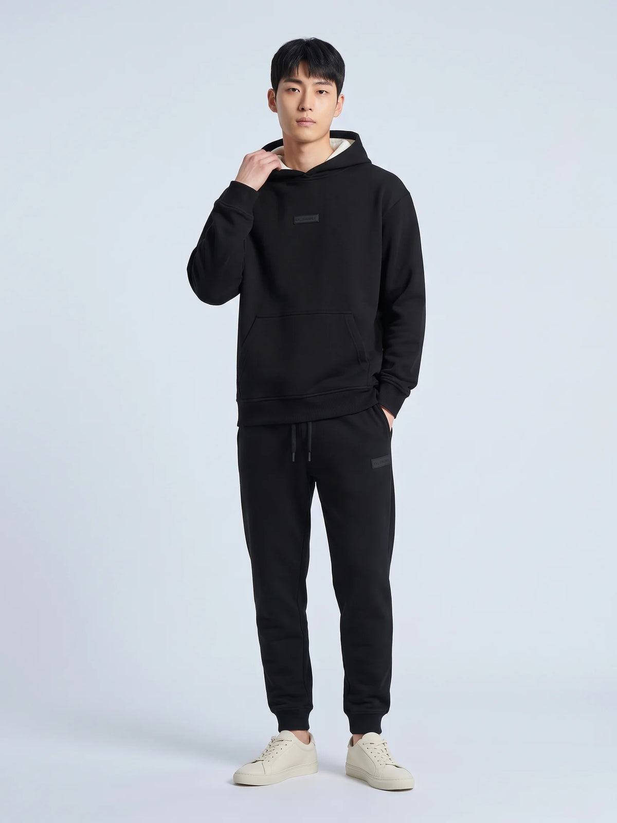 Black organic cotton hoodie, Unidentity Identity Hoodie, full-length front view with contrast hood lining and Core joggers, streetwear from Dubai #color_black