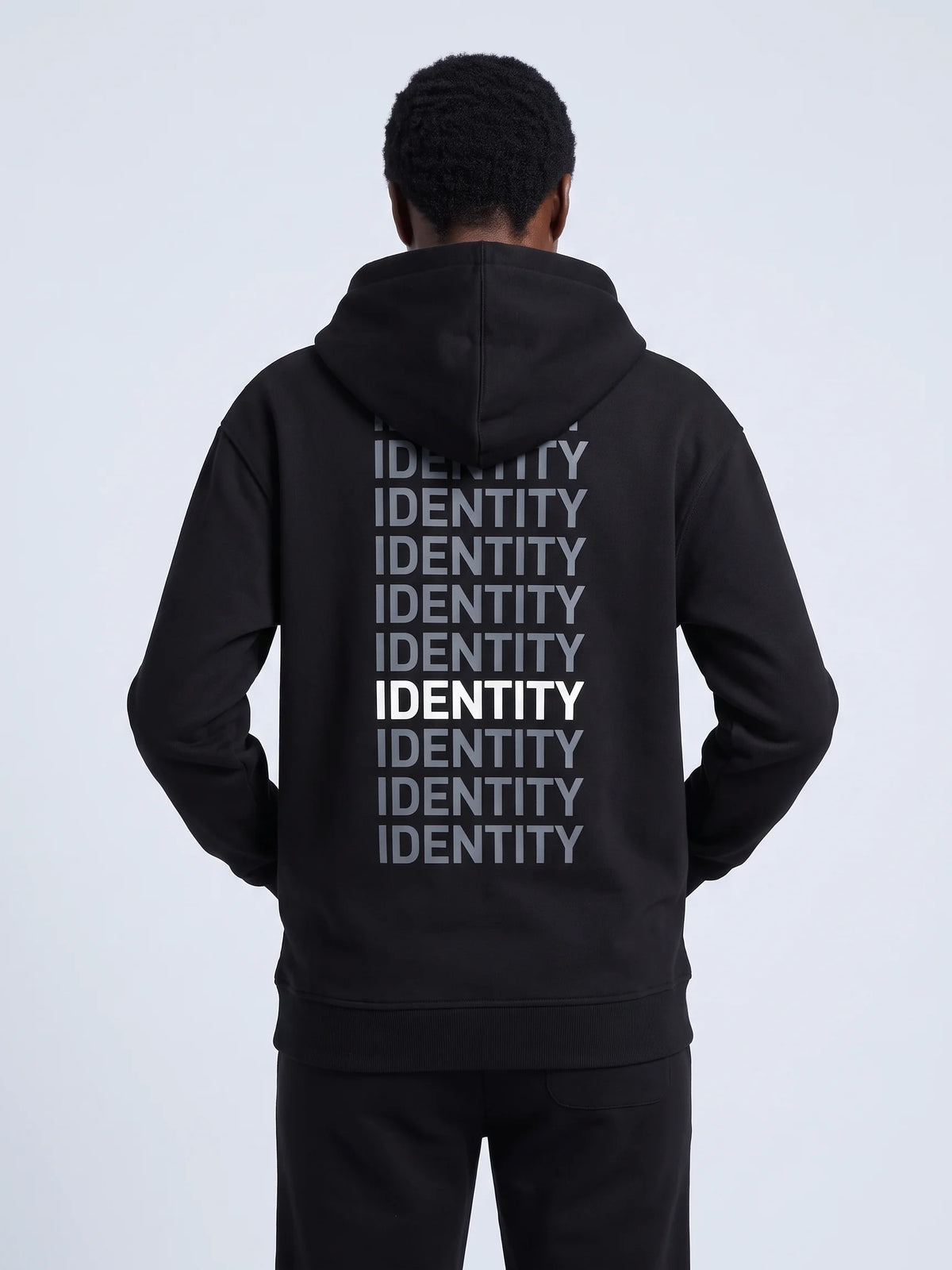 Black regular fit hoodie, Unidentity Identity Regular Fit Hoodie, back close-up of the gray and white IDENTITY print worn by woman, streetwear #color_black