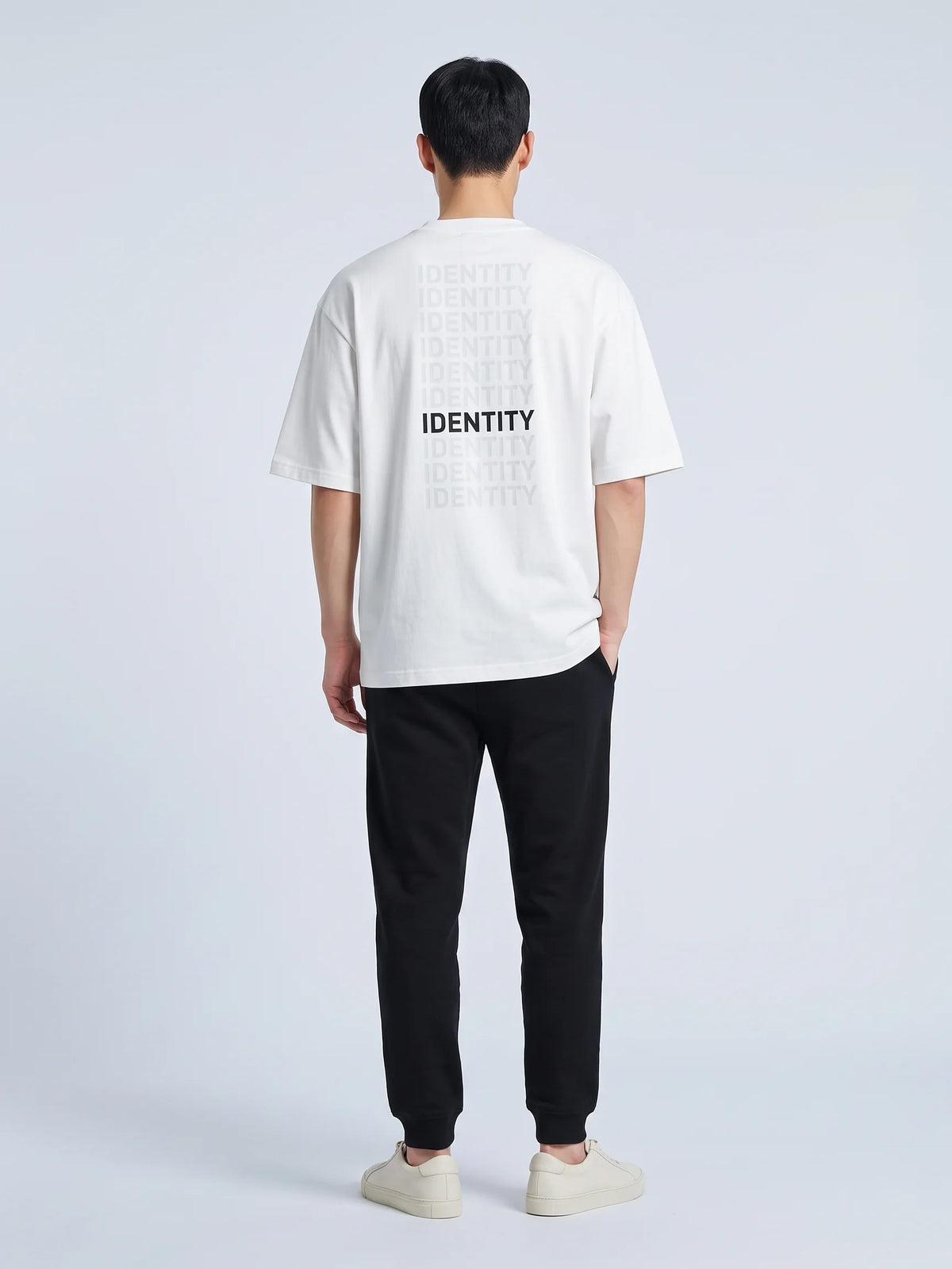 White heavyweight oversized t-shirt, Unidentity Identity Tee, full-length back view of the IDENTITY print with black Core joggers, streetwear #color_white