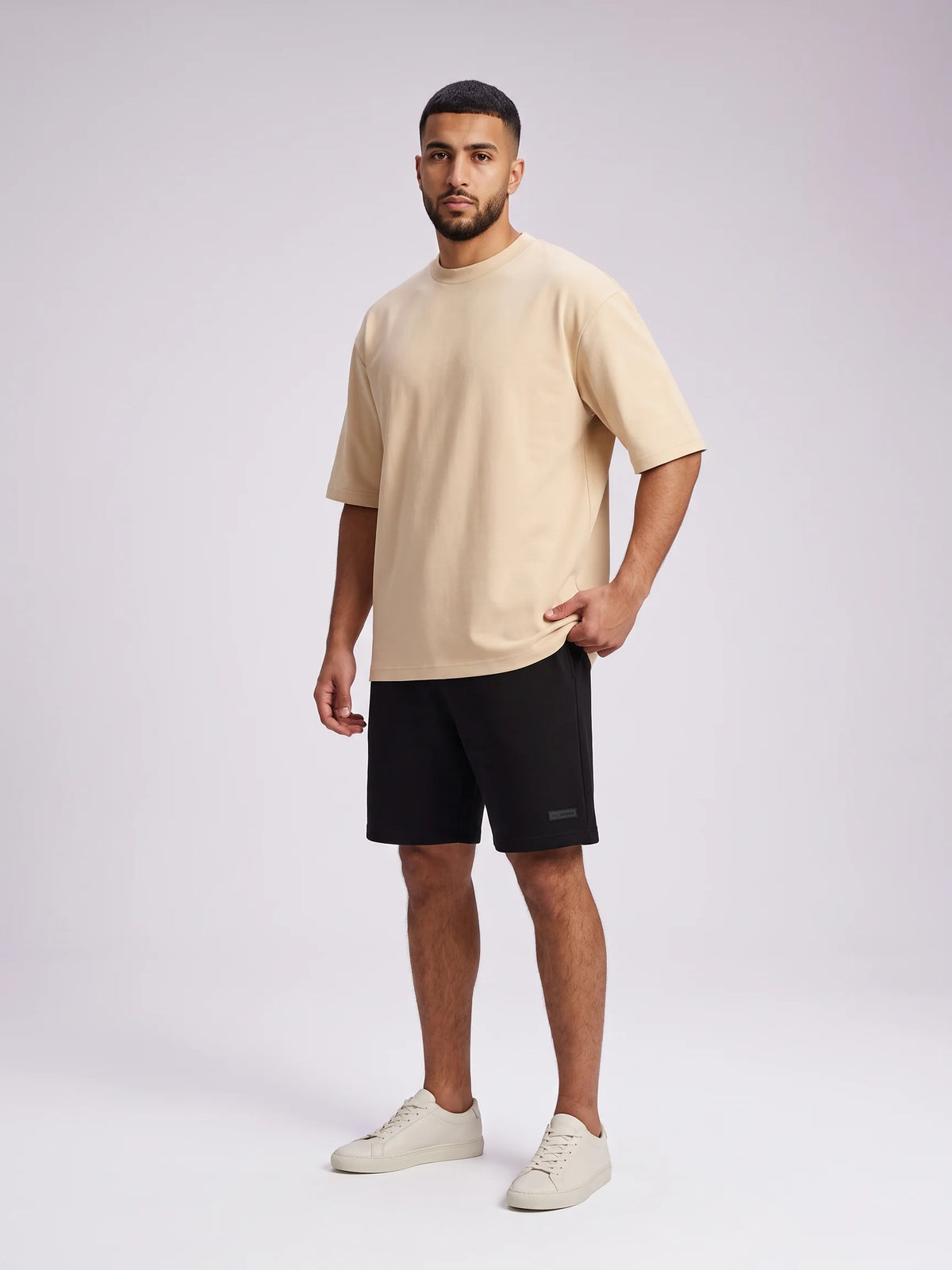 Beige oversized t-shirt in organic cotton, Unidentity Foundation Tee, full-length front view on a man in a plain graphic-free design, Dubai streetwear #color_beige